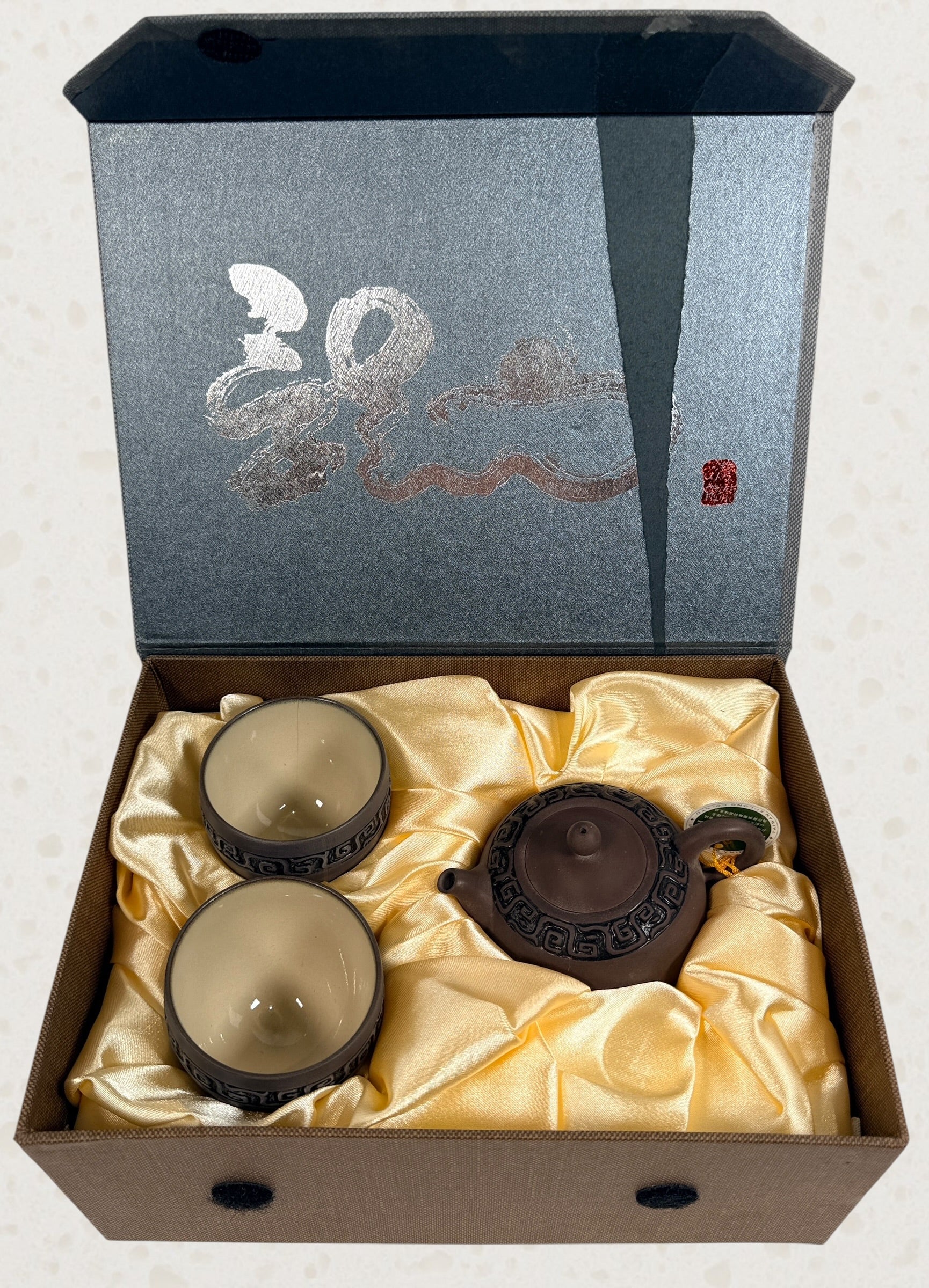 Modern Taiwanese clay tea set with teapot and two cups in original satin-lined gift box featuring Yixing-inspired styling and geometric carved detailing.