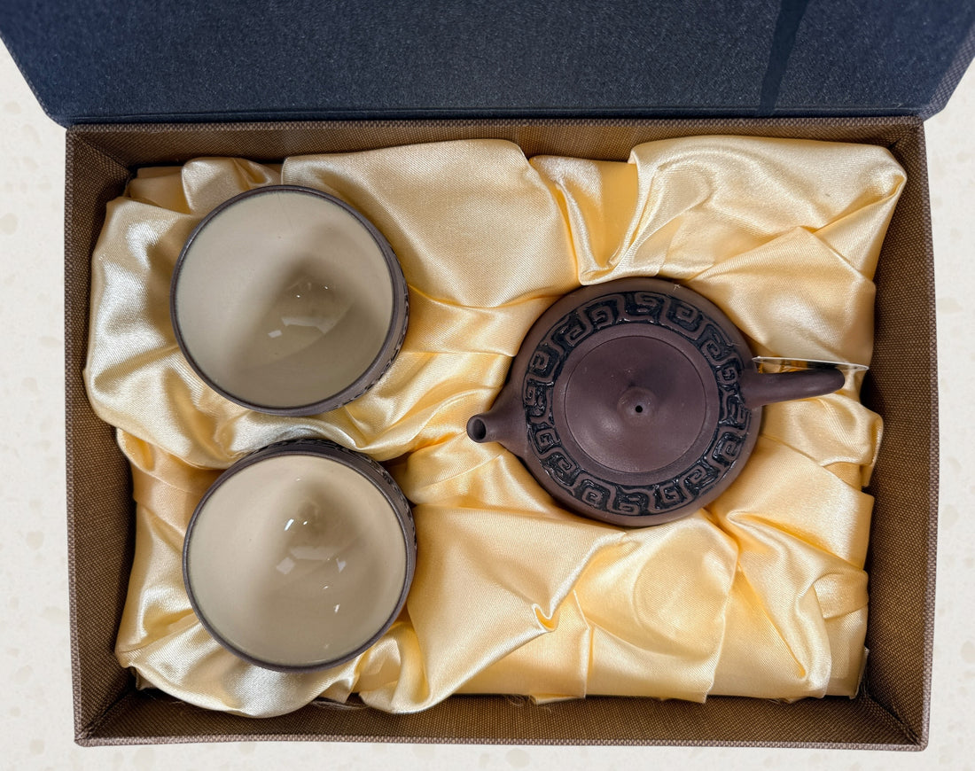 Modern Taiwanese clay tea set with teapot and two cups in original satin-lined gift box featuring Yixing-inspired styling and geometric carved detailing.