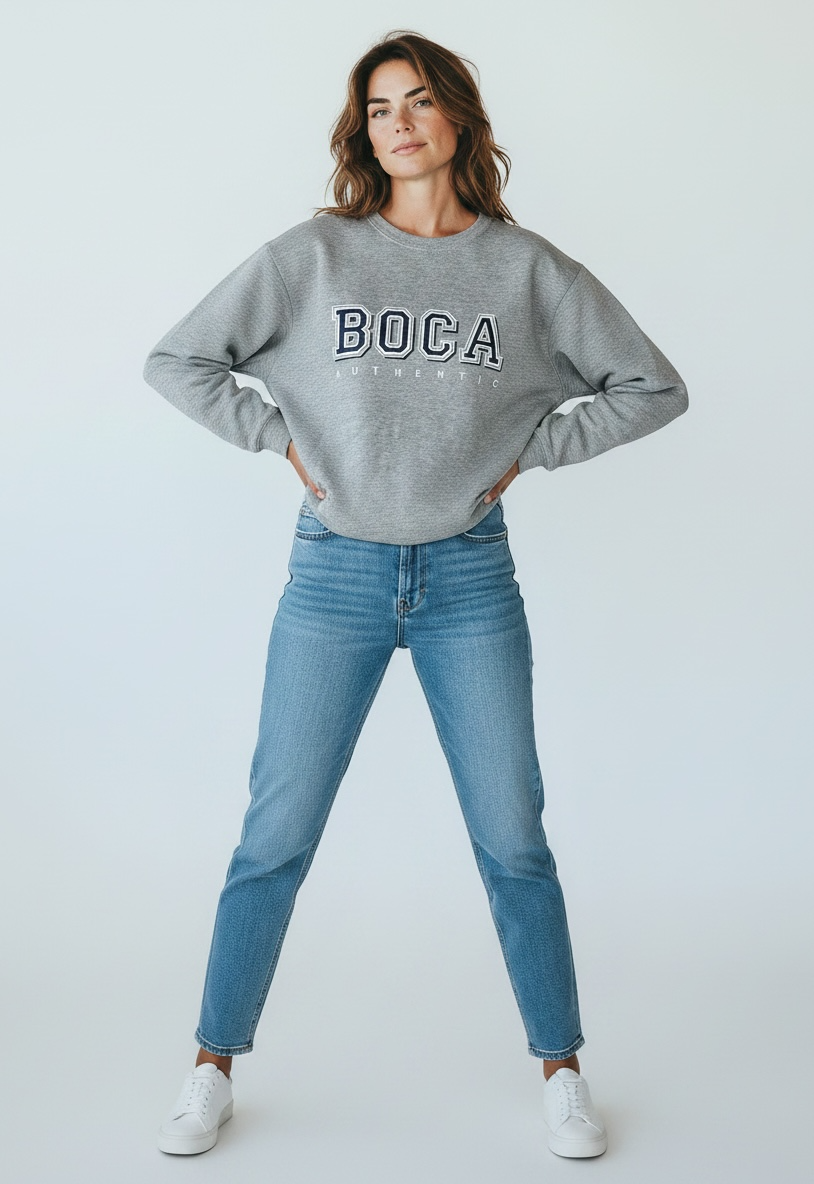 Woman wearing a gray sweatshirt with 'BOCA' text and blue jeans on a white background
