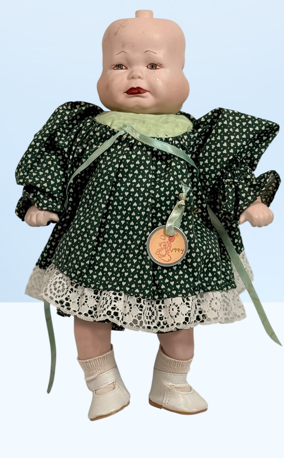 Vintage 1994 three-face baby doll with rotating expressions, lace dress, and novelty design. Rare collectible doll for vintage toy and decor collectors.