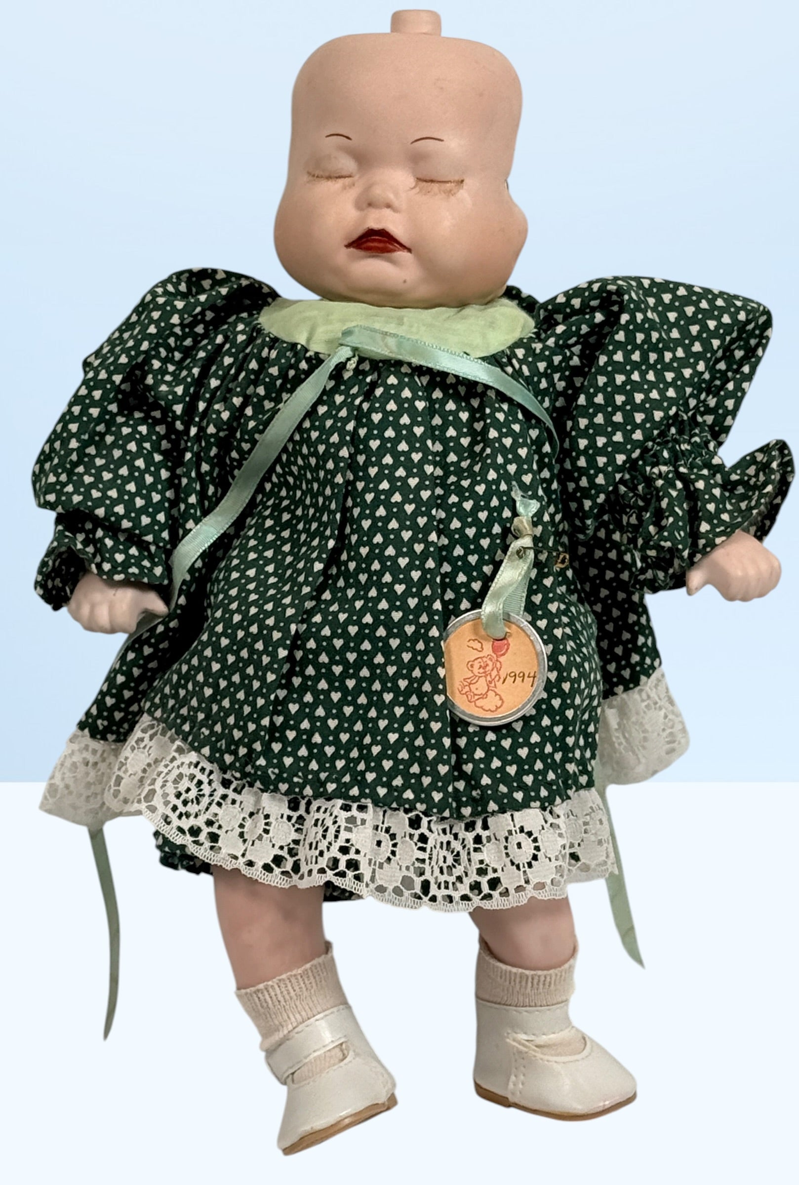 Vintage 1994 three-face baby doll with rotating expressions, lace dress, and novelty design. Rare collectible doll for vintage toy and decor collectors.