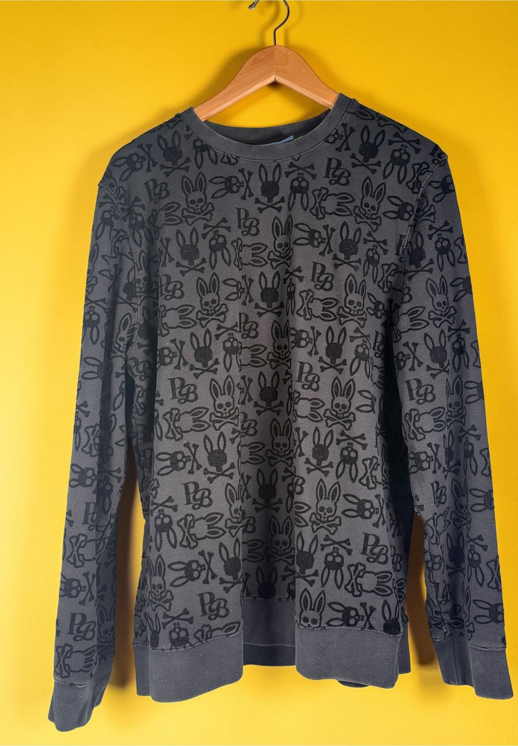 Psycho Bunny skull logo sweatshirt in charcoal grey with all-over flocked graphic print and slim modern streetwear fit.