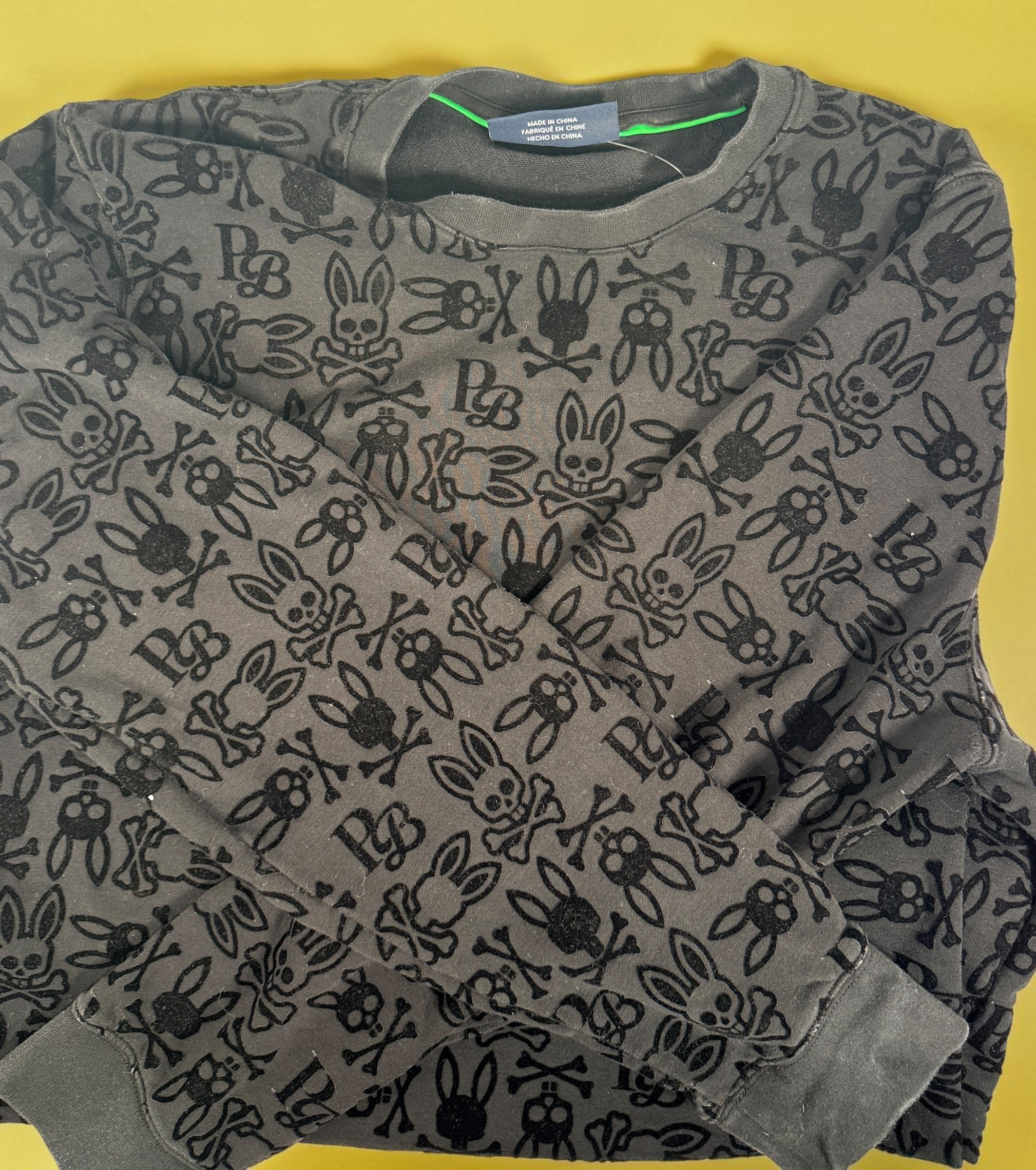 Psycho Bunny skull logo sweatshirt in charcoal grey with all-over flocked graphic print and slim modern streetwear fit.