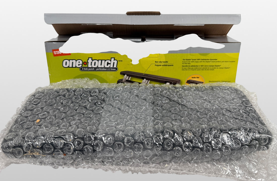 Staples One-Touch 3-hole punch model 26612 with 20-sheet capacity in open-box condition. Includes original packaging and locking flat design.