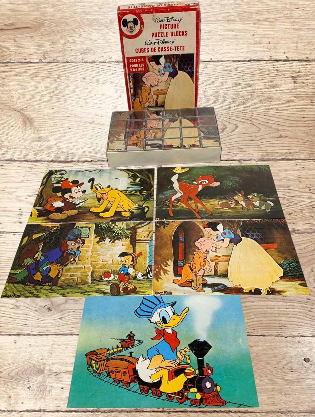 Vintage Walt Disney puzzle block set with original box featuring Snow White, Bambi, Mickey Mouse, Donald Duck, and Pinocchio scenes.