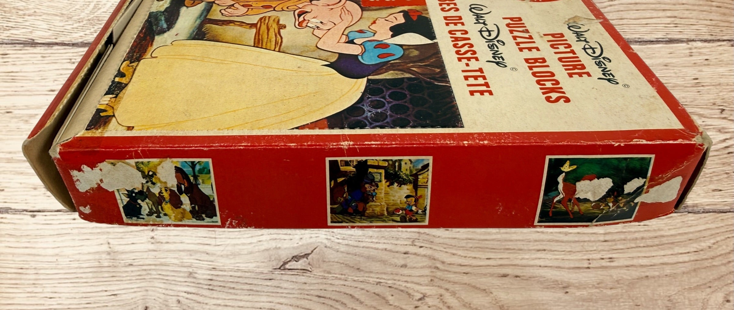 Vintage Walt Disney puzzle block set with original box featuring Snow White, Bambi, Mickey Mouse, Donald Duck, and Pinocchio scenes.