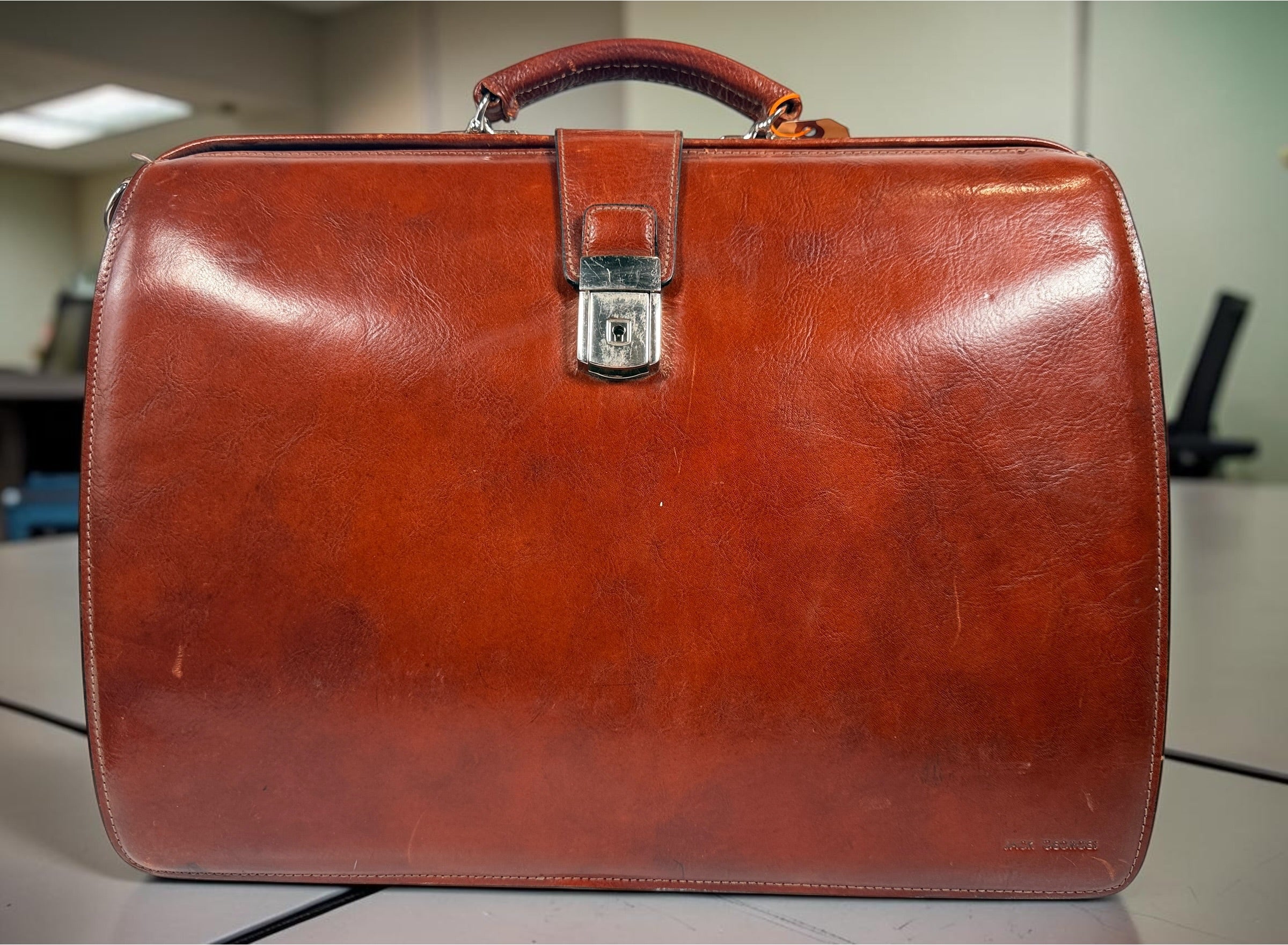 Authentic Jack Georges triple gusset leather briefcase in cognac brown featuring full-grain leather, locking closure, and spacious executive organization.