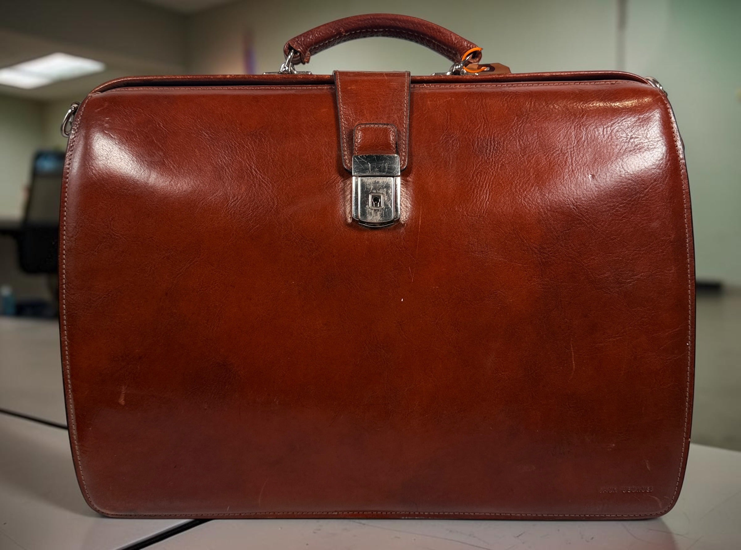 Authentic Jack Georges triple gusset leather briefcase in cognac brown featuring full-grain leather, locking closure, and spacious executive organization.