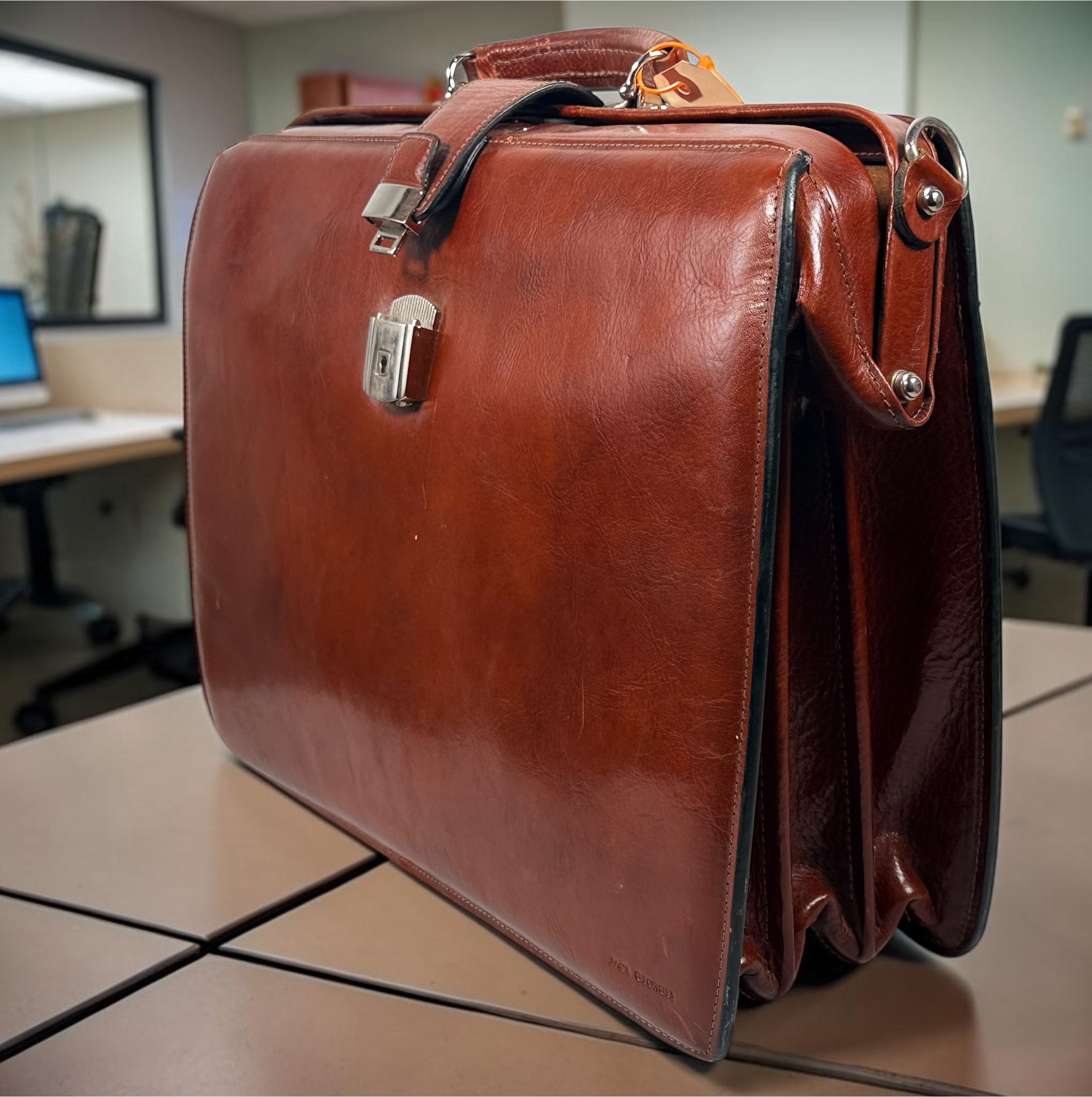 Authentic Jack Georges triple gusset leather briefcase in cognac brown featuring full-grain leather, locking closure, and spacious executive organization.
