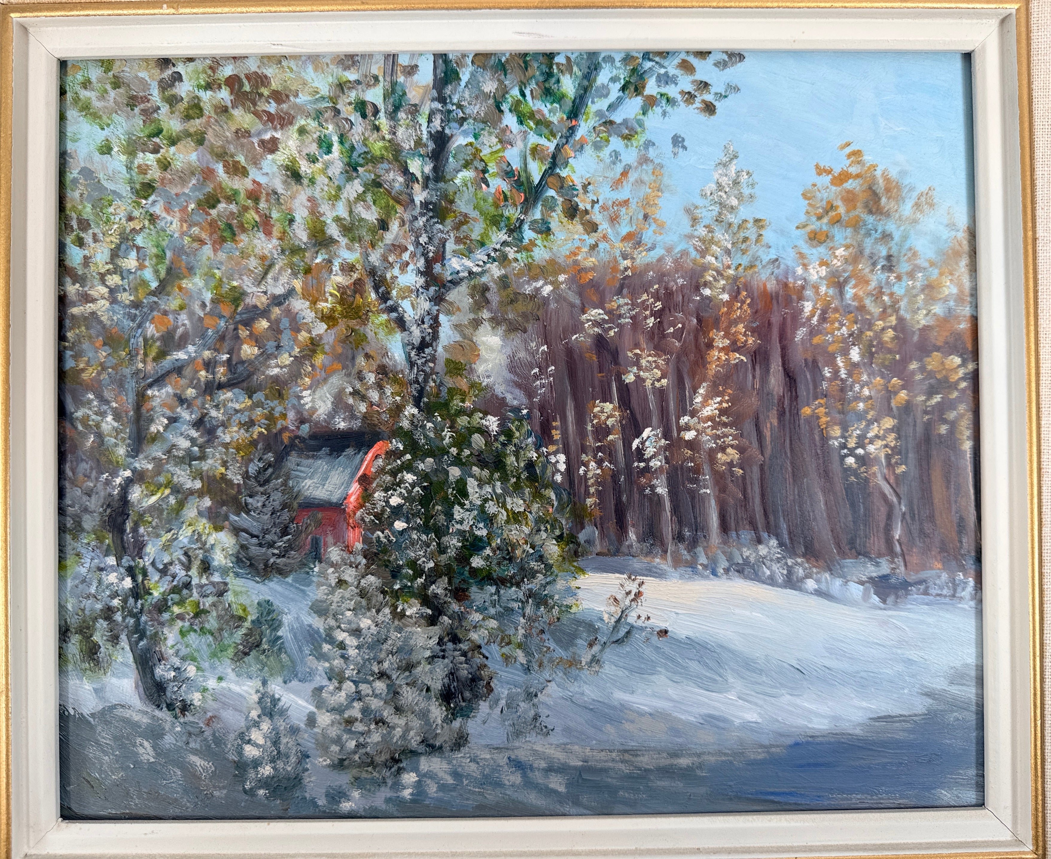 Framed painting of a snowy landscape with trees and a small building.