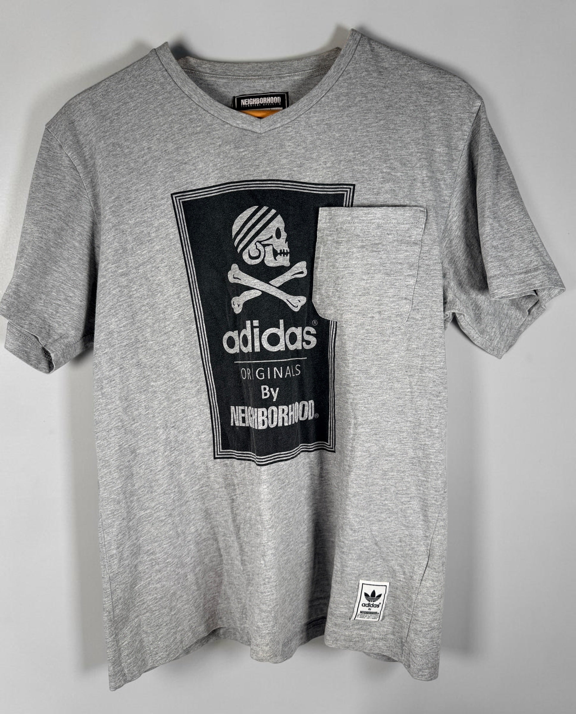 Authentic Adidas Originals x Neighborhood graphic T-shirt in size medium featuring skull artwork, V-neck styling, and collectible Japanese streetwear appeal.