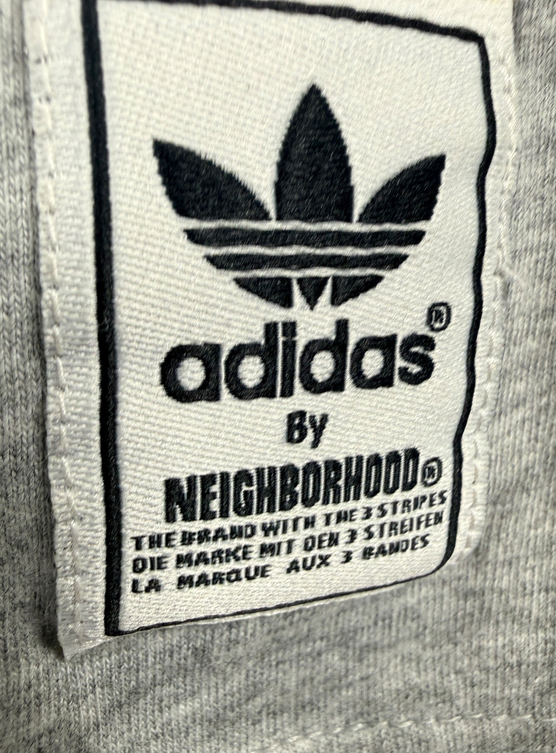 Authentic Adidas Originals x Neighborhood graphic T-shirt in size medium featuring skull artwork, V-neck styling, and collectible Japanese streetwear appeal.