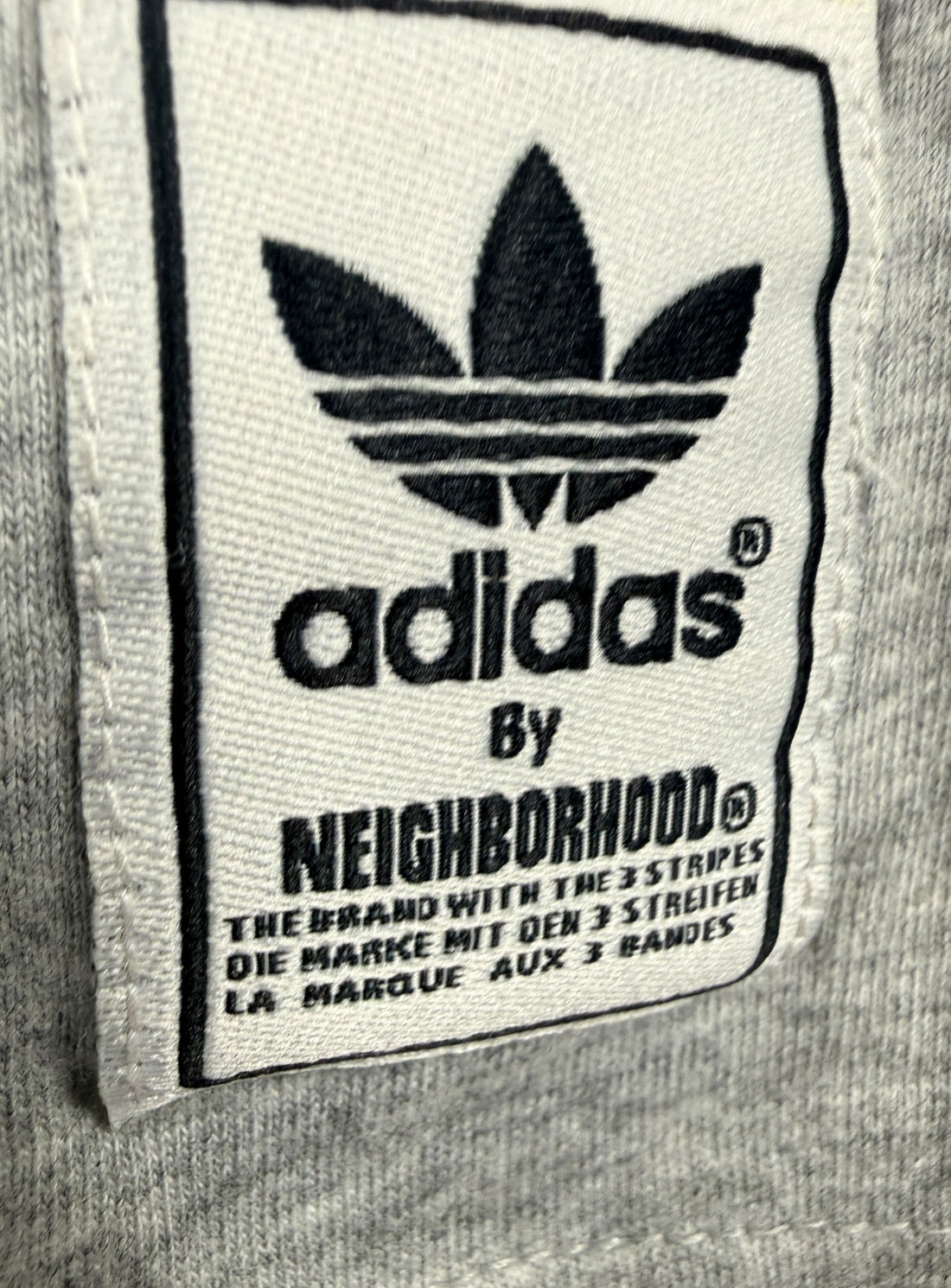 Authentic Adidas Originals x Neighborhood graphic T-shirt in size medium featuring skull artwork, V-neck styling, and collectible Japanese streetwear appeal.