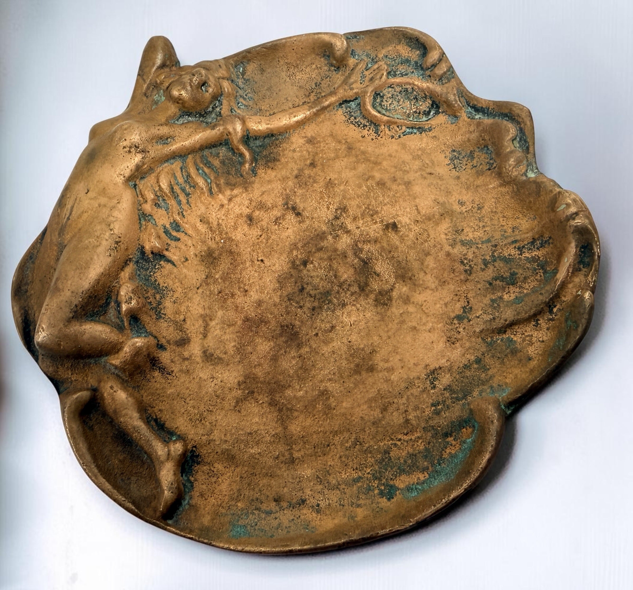 Art Nouveau style figural vide-poche tray featuring a reclining nude maiden in cast metal with bronze-tone finish and verdigris patina. Decorative vintage accent.