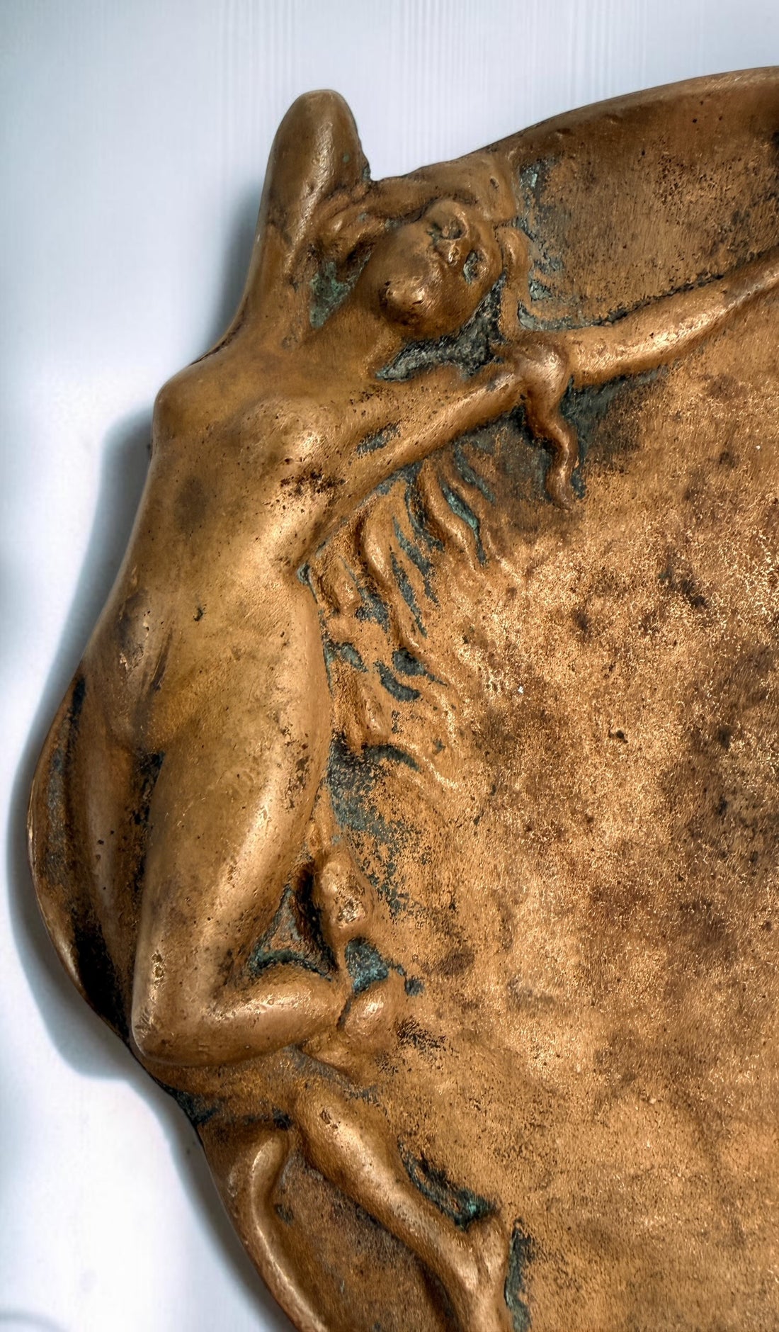Art Nouveau style figural vide-poche tray featuring a reclining nude maiden in cast metal with bronze-tone finish and verdigris patina. Decorative vintage accent.