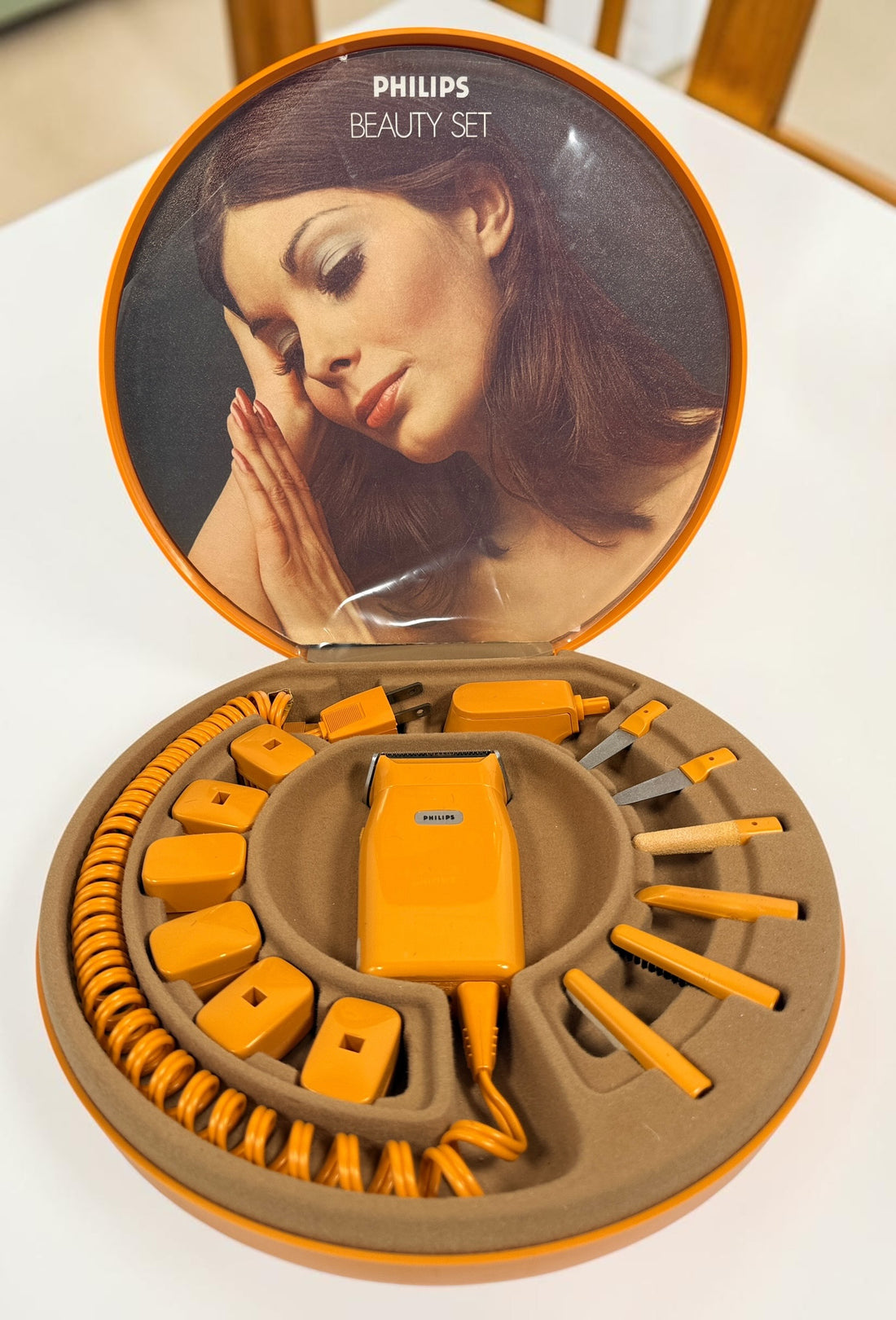 Vintage Philips Beauty Set from the early 1970s with original orange case, grooming accessories, paperwork, and Space Age styling. Complete collectible kit.