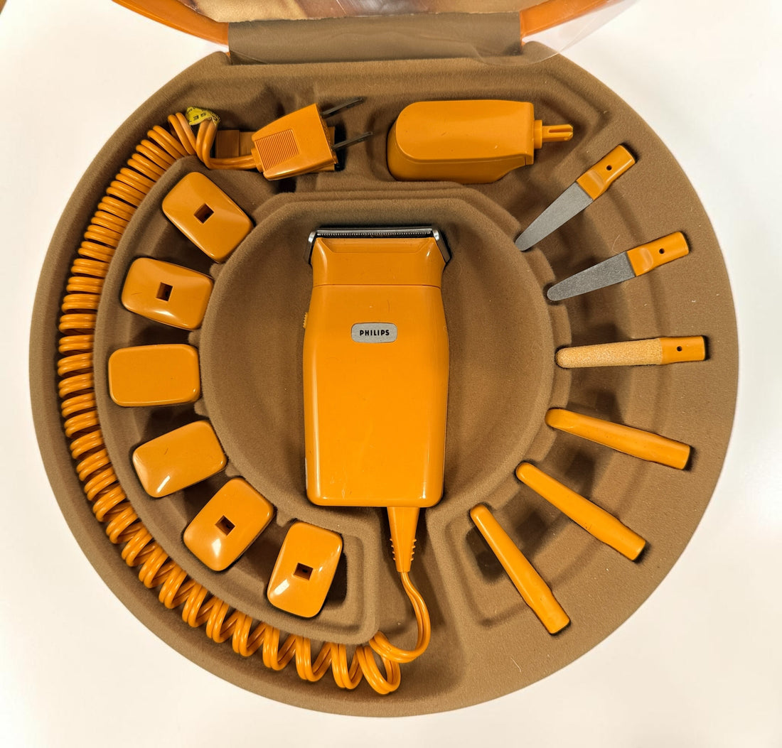 Vintage Philips Beauty Set from the early 1970s with original orange case, grooming accessories, paperwork, and Space Age styling. Complete collectible kit.
