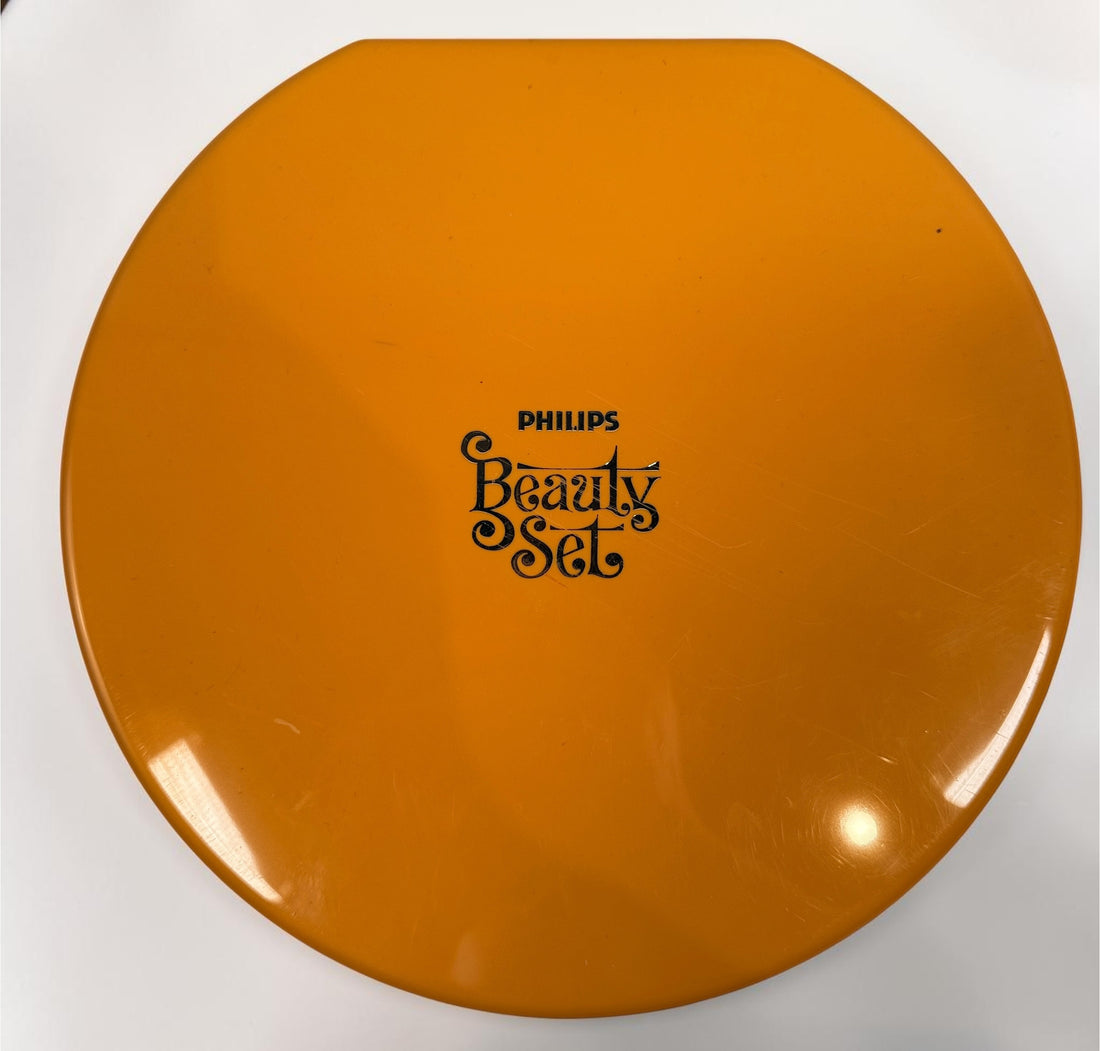 Vintage Philips Beauty Set from the early 1970s with original orange case, grooming accessories, paperwork, and Space Age styling. Complete collectible kit.
