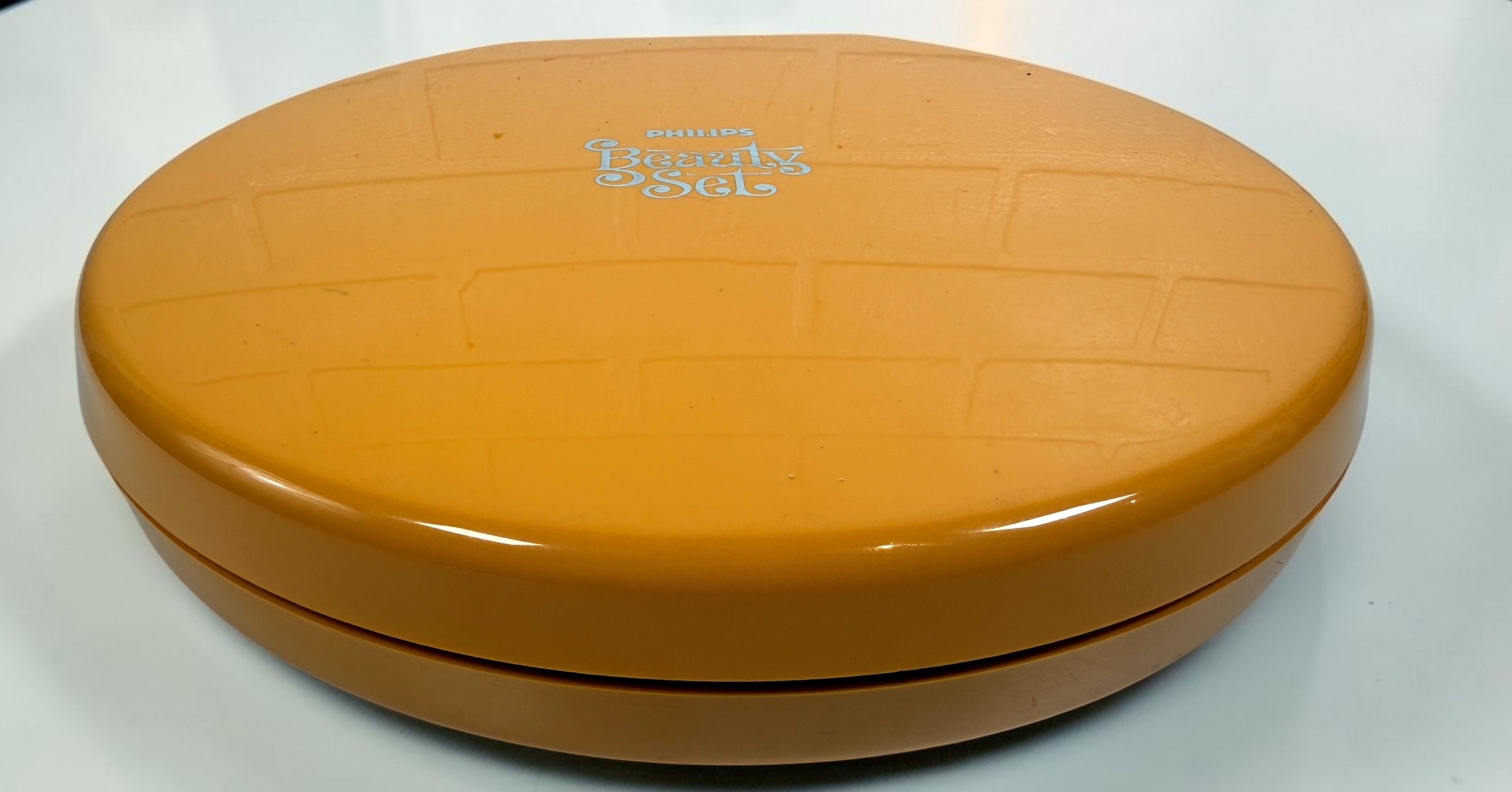 Vintage Philips Beauty Set from the early 1970s with original orange case, grooming accessories, paperwork, and Space Age styling. Complete collectible kit.