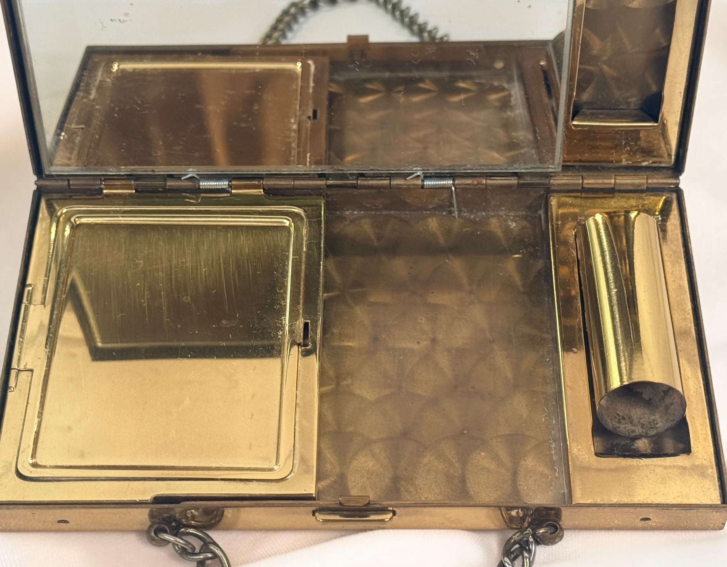 Vintage mother-of-pearl minaudière compact purse with mirror, lipstick holder, and vanity compartments. Elegant mid-century evening accessory.