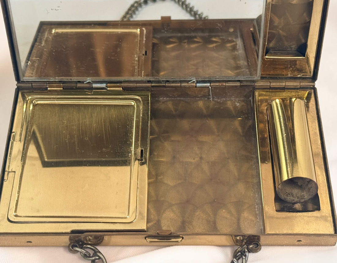 Vintage mother-of-pearl minaudière compact purse with mirror, lipstick holder, and vanity compartments. Elegant mid-century evening accessory.