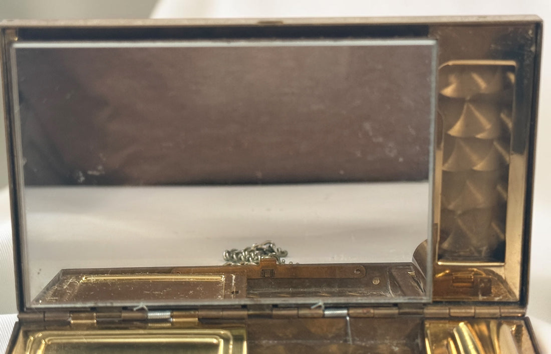 Vintage mother-of-pearl minaudière compact purse with mirror, lipstick holder, and vanity compartments. Elegant mid-century evening accessory.