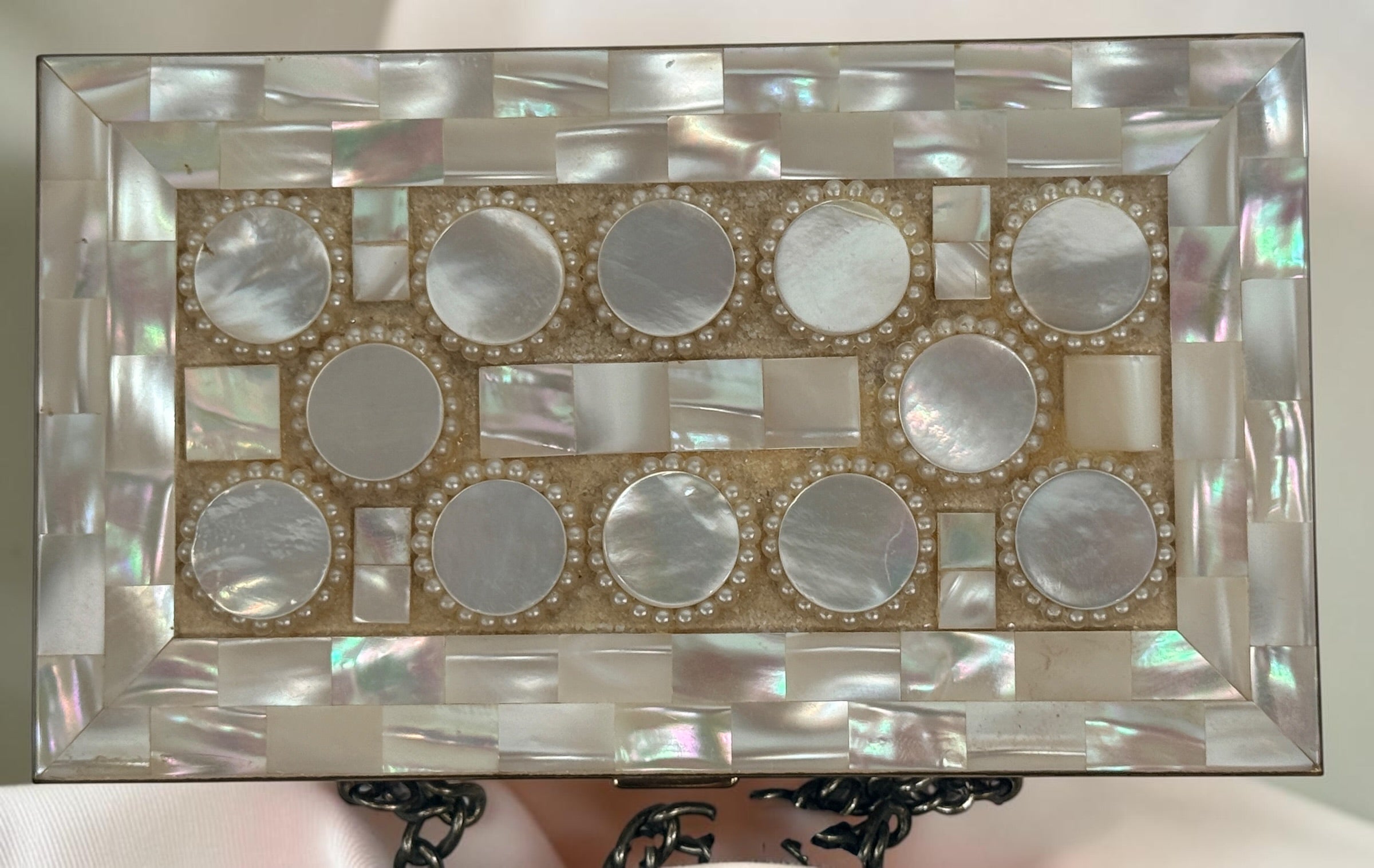 Vintage mother-of-pearl minaudière compact purse with mirror, lipstick holder, and vanity compartments. Elegant mid-century evening accessory.