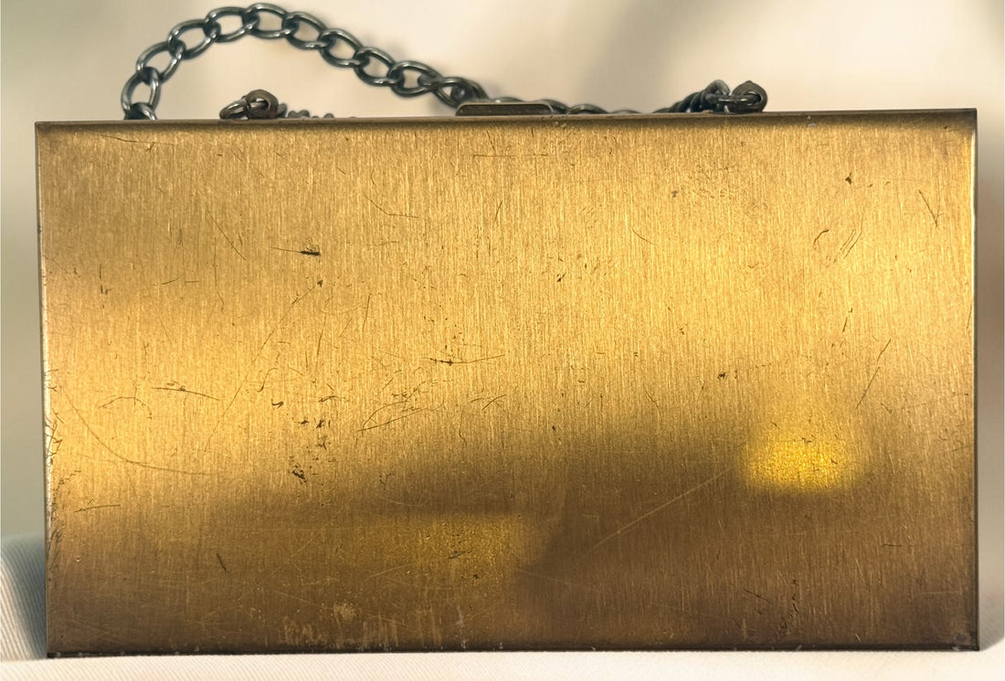 Vintage mother-of-pearl minaudière compact purse with mirror, lipstick holder, and vanity compartments. Elegant mid-century evening accessory.