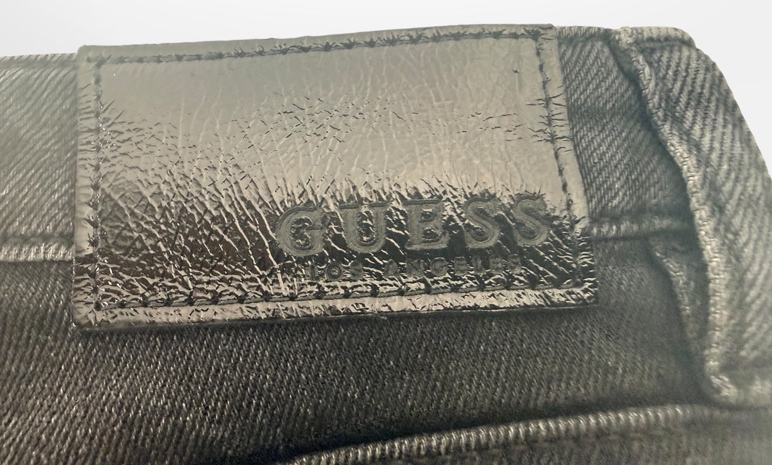 Close-up of a Guess branded wallet with a textured surface.