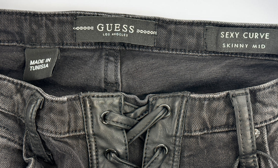 NWT GUESS Sexy Curve Skinny Mid jeans in black vintage wash featuring a lace-up front, stretch denim construction, and flattering curve fit. Size 29x27.
