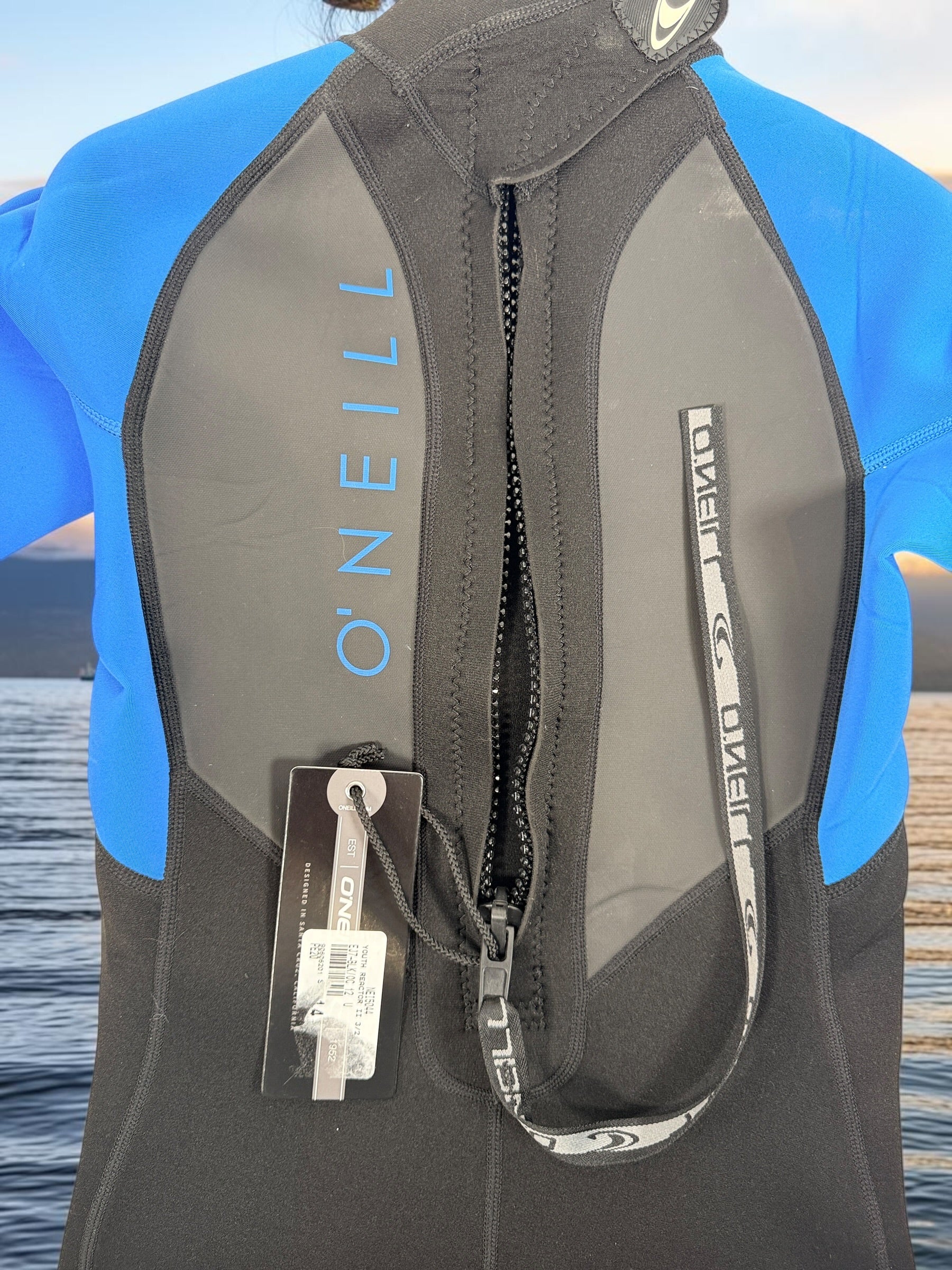 O’Neill Reactor II Youth 3/2mm full wetsuit size 12 in black and ocean blue. New with tags, ideal for surfing, swimming, paddleboarding, and watersports.