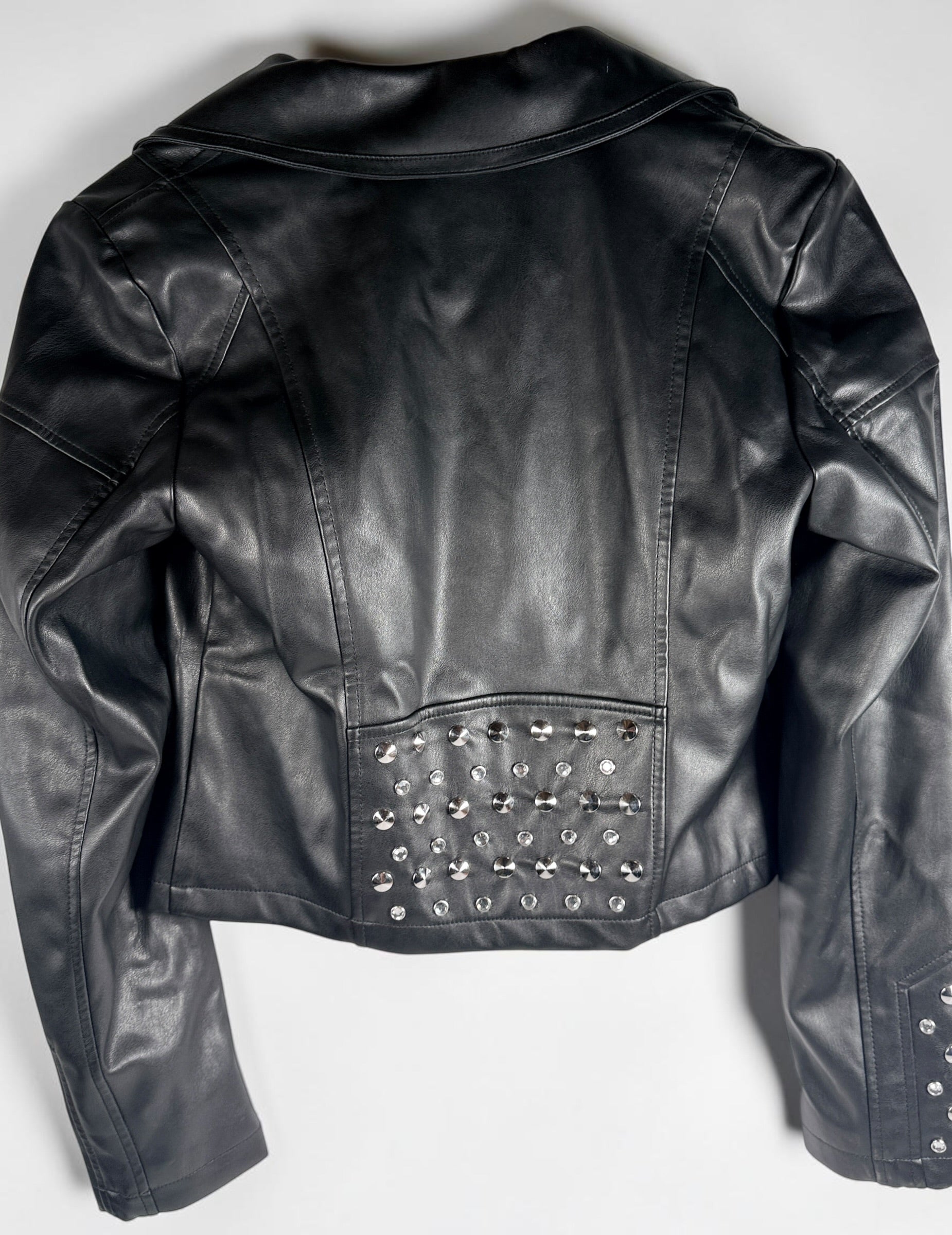 GUESS studded faux leather moto jacket in black, size medium. New with tags featuring rhinestone accents, asymmetrical zip closure and cropped biker styling.