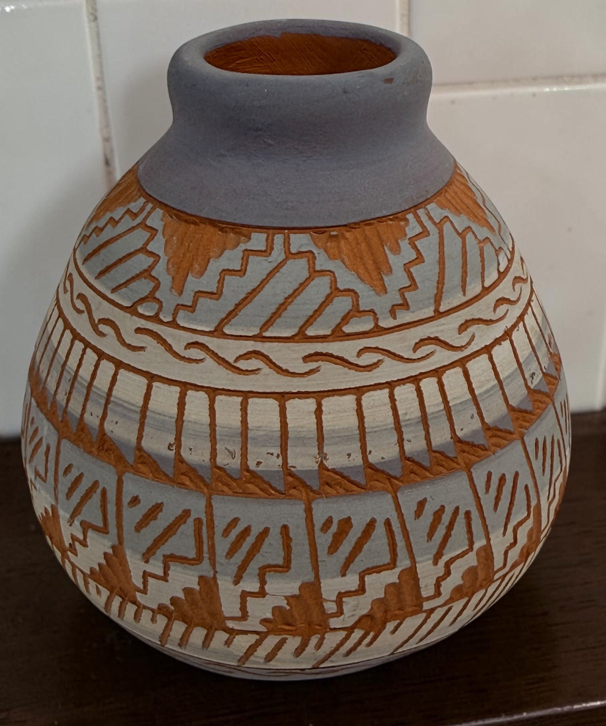 Signed S. Benaly Shiprock NM pottery vase featuring hand-carved Southwest geometric decoration. Vintage studio pottery from New Mexico.