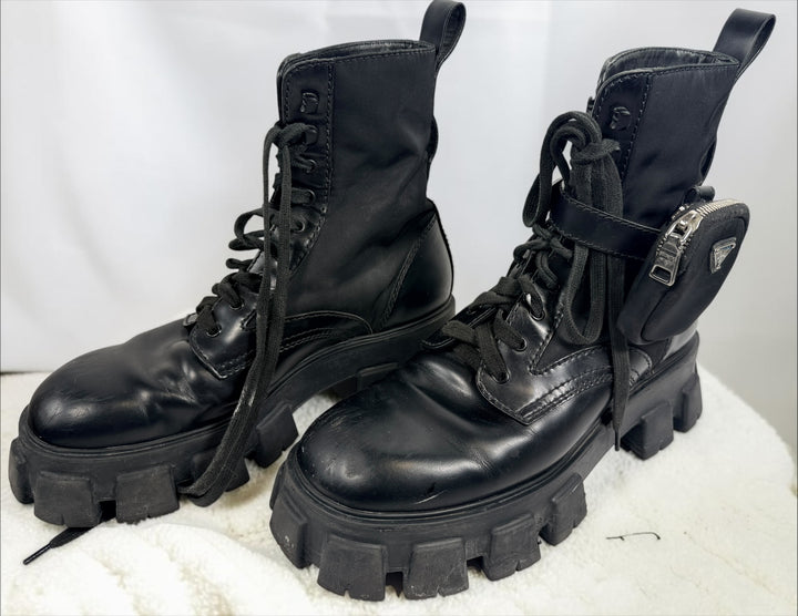 Black Monolith style combat boots with oversized lug soles and one detachable utility pouch. Size 39.5. Bold designer-inspired fashion footwear.
