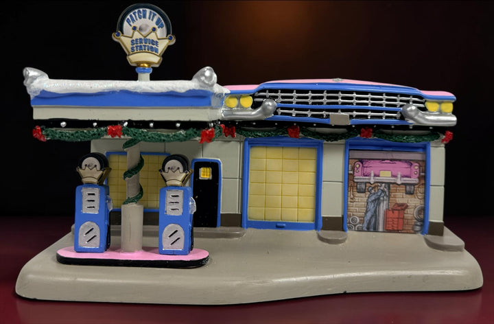 Retired 2009 Hawthorne Village Elvis Presley Patch It Up Service Station from the Rock ‘n’ Roll Holiday Village collection. Light cord not included.