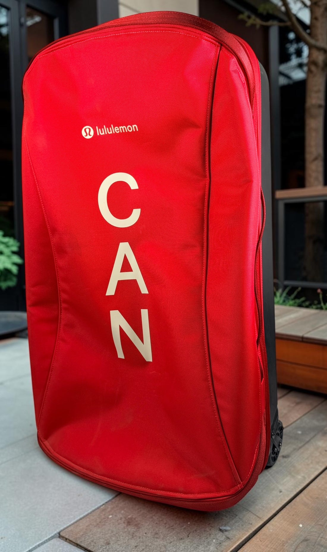 Official Lululemon Team Canada rolling suitcase in vibrant Olympic red. Large wheeled travel luggage with spacious interior, compression straps, and rare Canadian Olympic branding