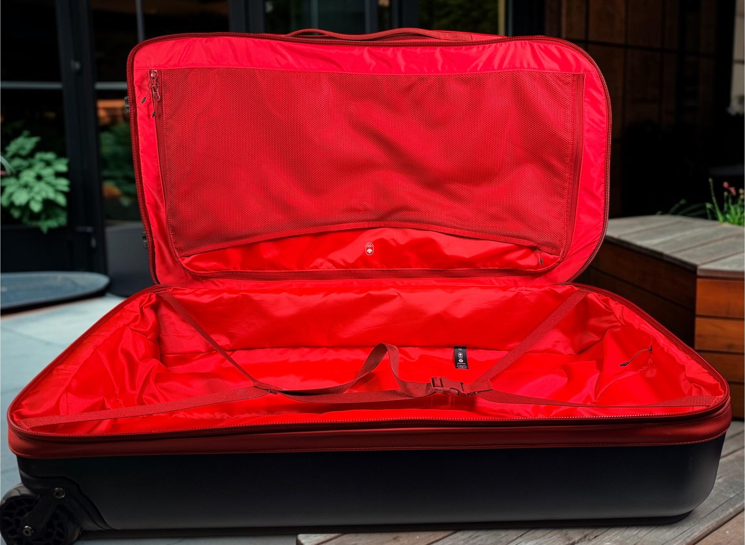 Official Lululemon Team Canada rolling suitcase in vibrant Olympic red. Large wheeled travel luggage with spacious interior, compression straps, and rare Canadian Olympic branding