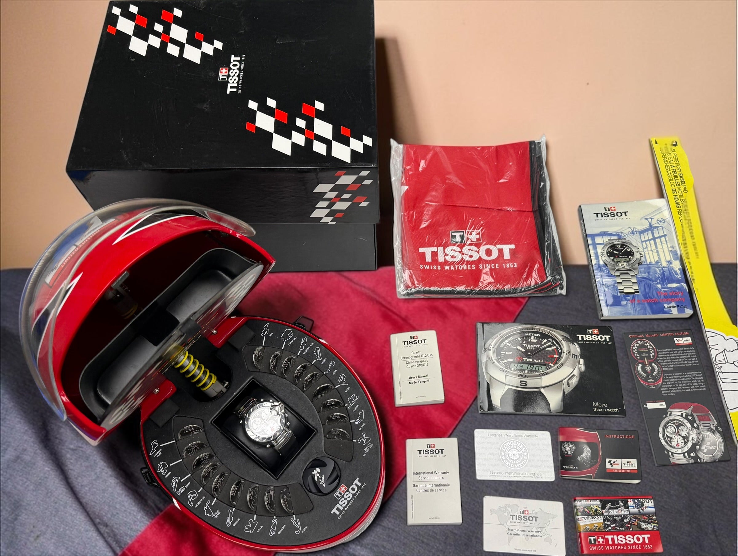 Rare Tissot T-Race MotoGP 2007 Limited Edition chronograph No. 1700/7002 with original helmet case, manuals, warranty card, and circuit medallions. Complete collector set.