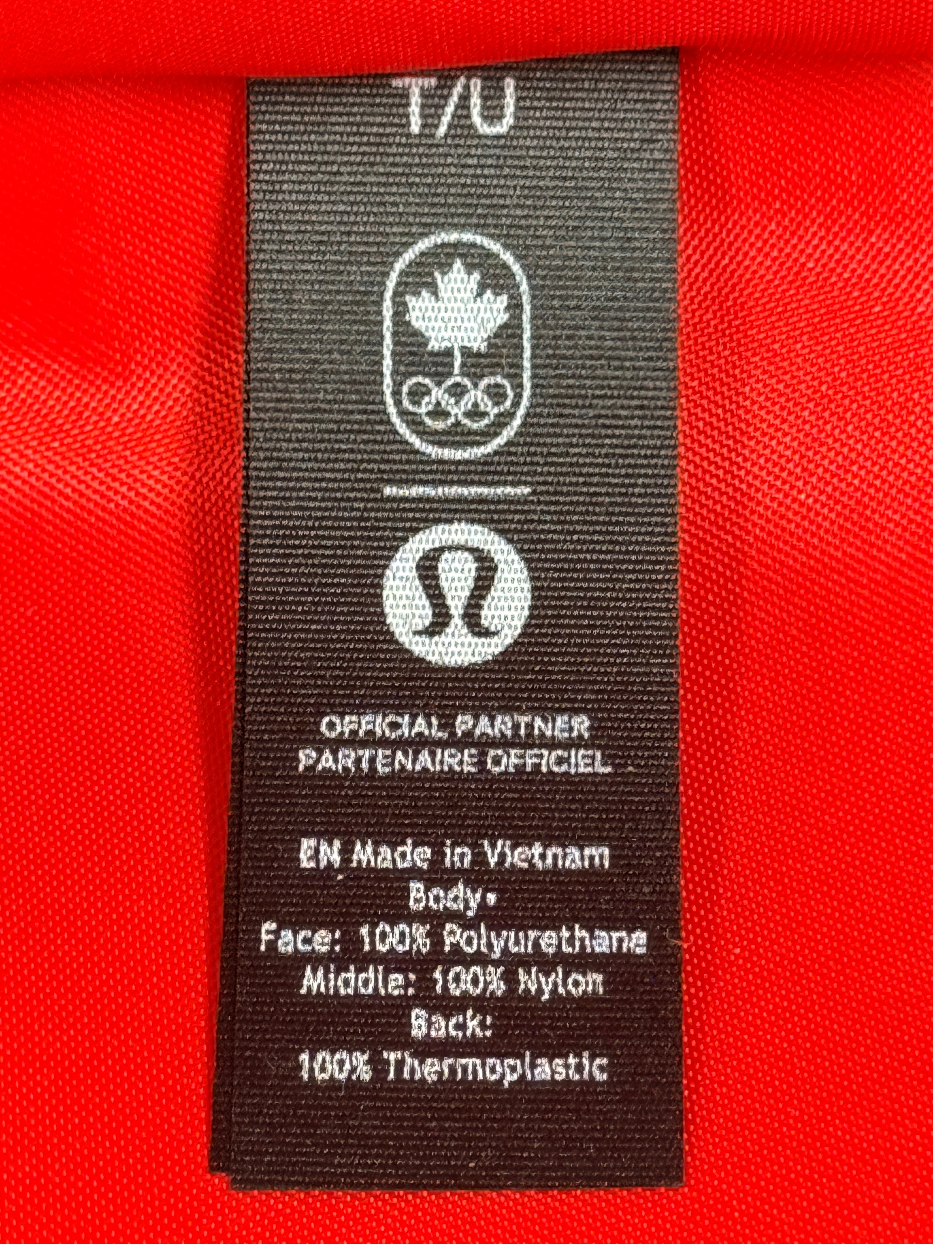 Official Lululemon Team Canada rolling suitcase in vibrant Olympic red. Large wheeled travel luggage with spacious interior, compression straps, and rare Canadian Olympic branding