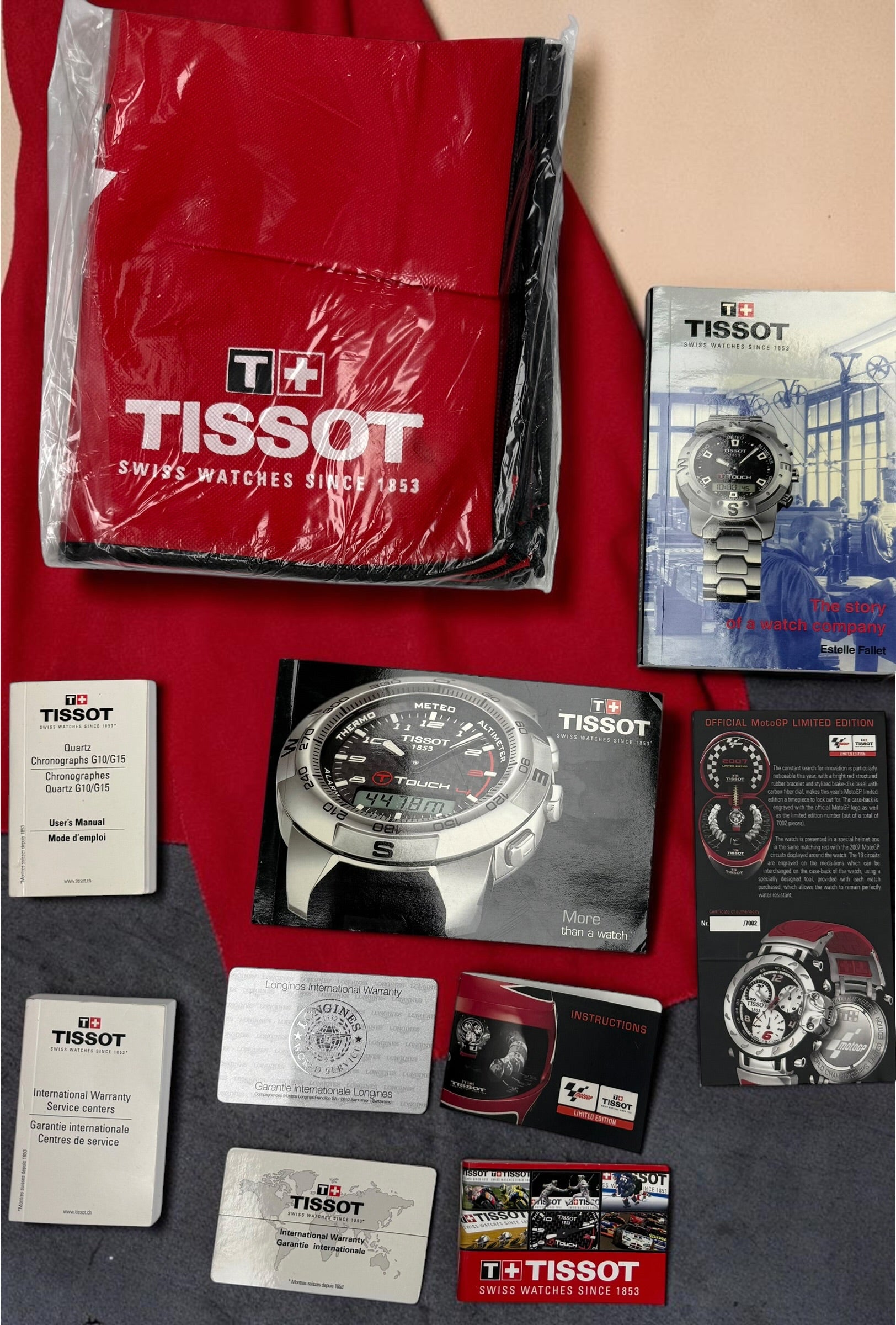 Rare Tissot T-Race MotoGP 2007 Limited Edition chronograph No. 1700/7002 with original helmet case, manuals, warranty card, and circuit medallions. Complete collector set.