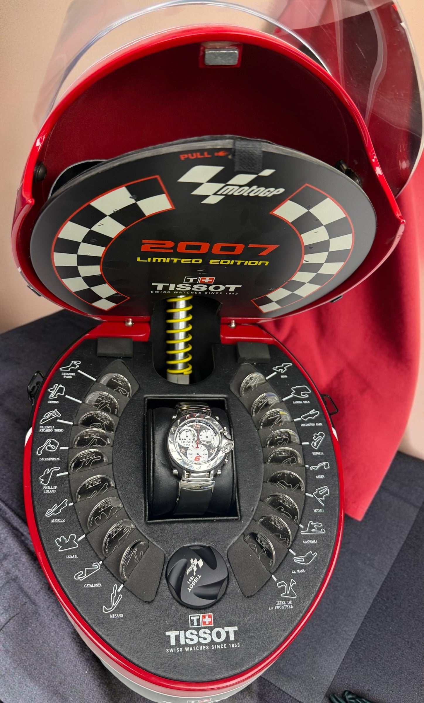 Rare Tissot T-Race MotoGP 2007 Limited Edition chronograph No. 1700/7002 with original helmet case, manuals, warranty card, and circuit medallions. Complete collector set.