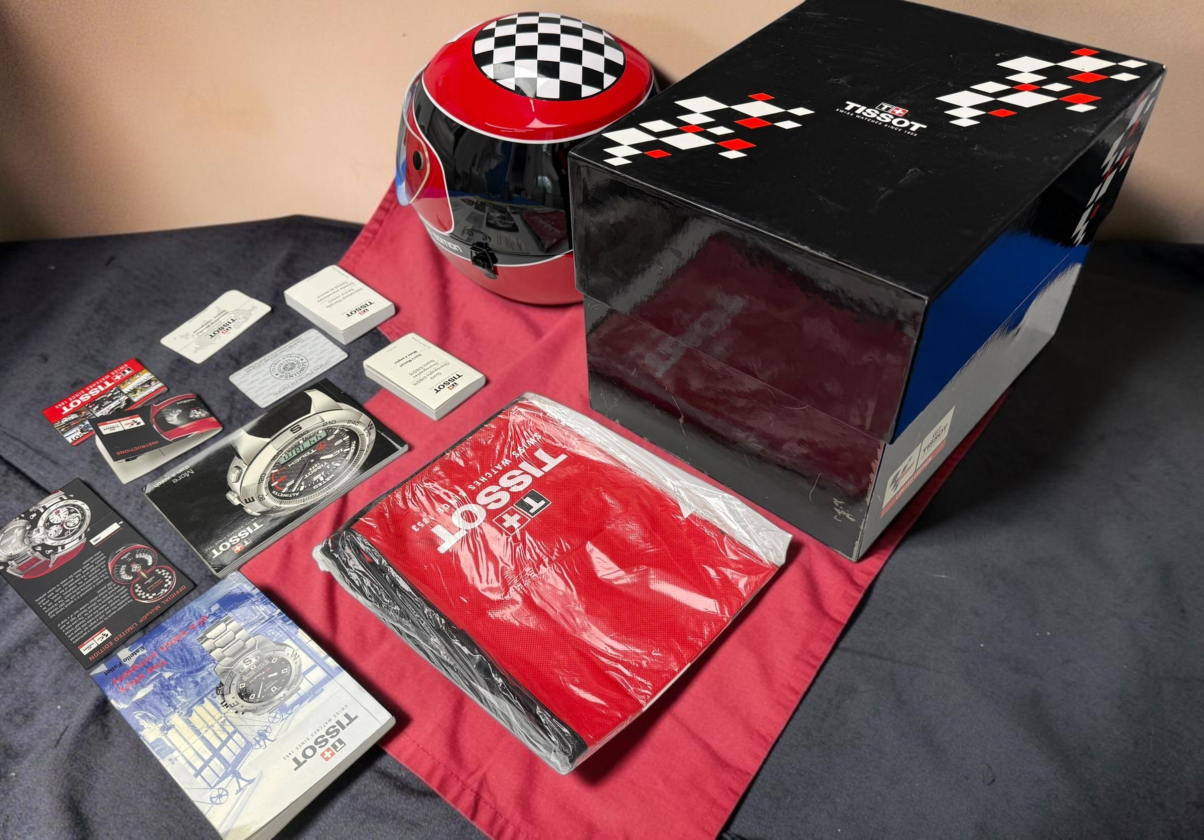 Rare Tissot T-Race MotoGP 2007 Limited Edition chronograph No. 1700/7002 with original helmet case, manuals, warranty card, and circuit medallions. Complete collector set.