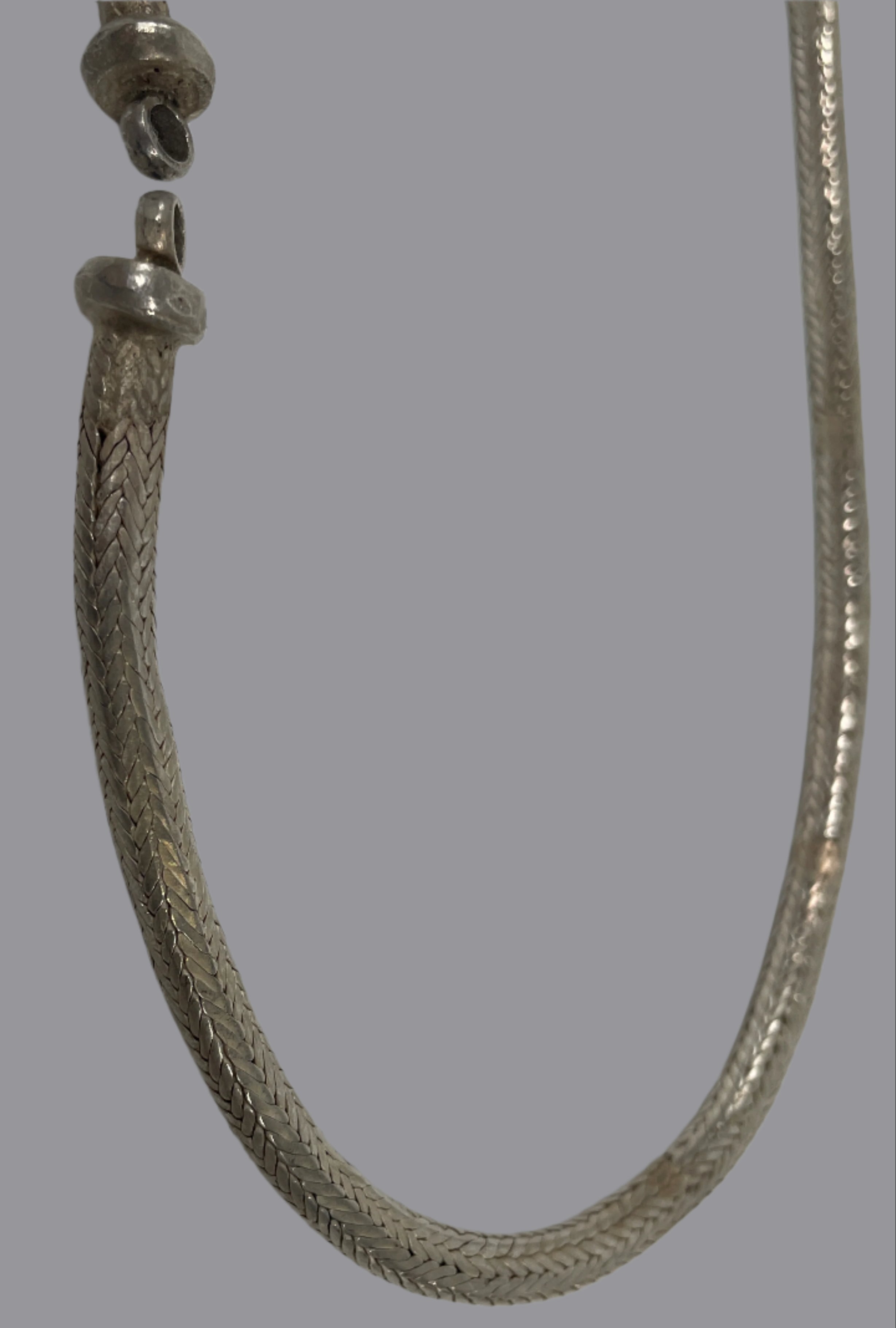 Silver bracelet on a light gray surface