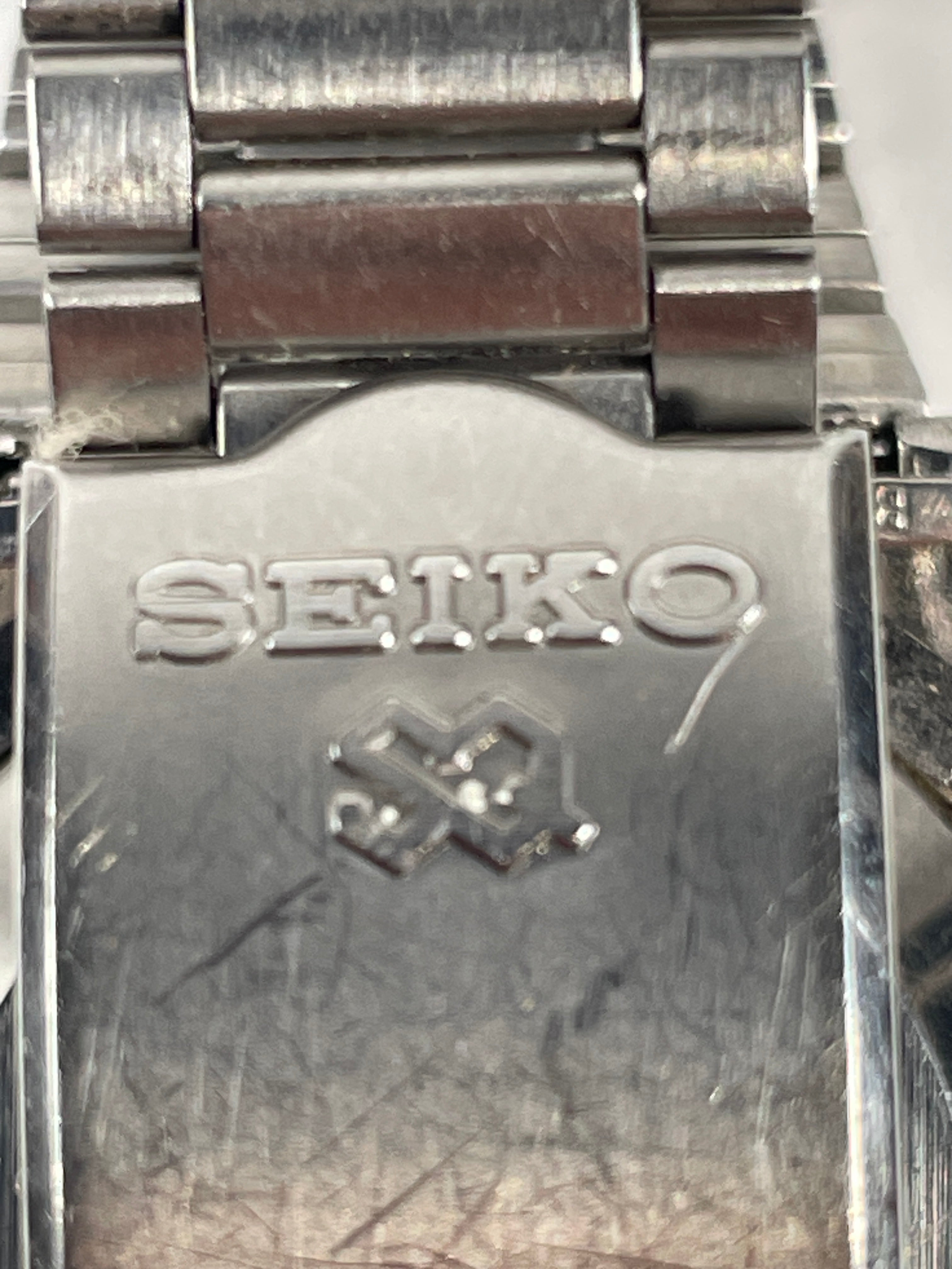 Close-up of a metallic watch band with Seiko logo
