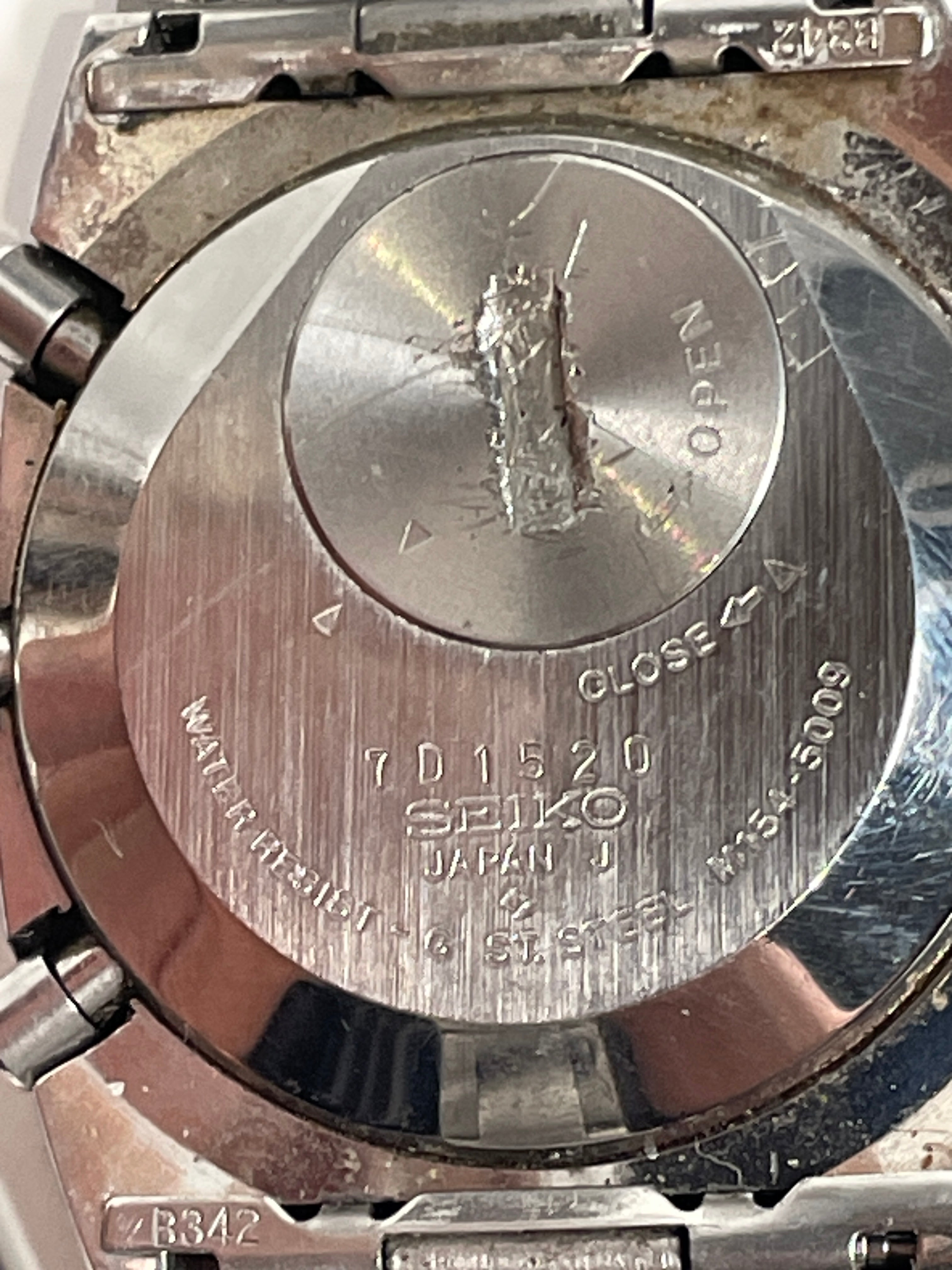 Close-up of a Seiko watch caseback with branding and model number.