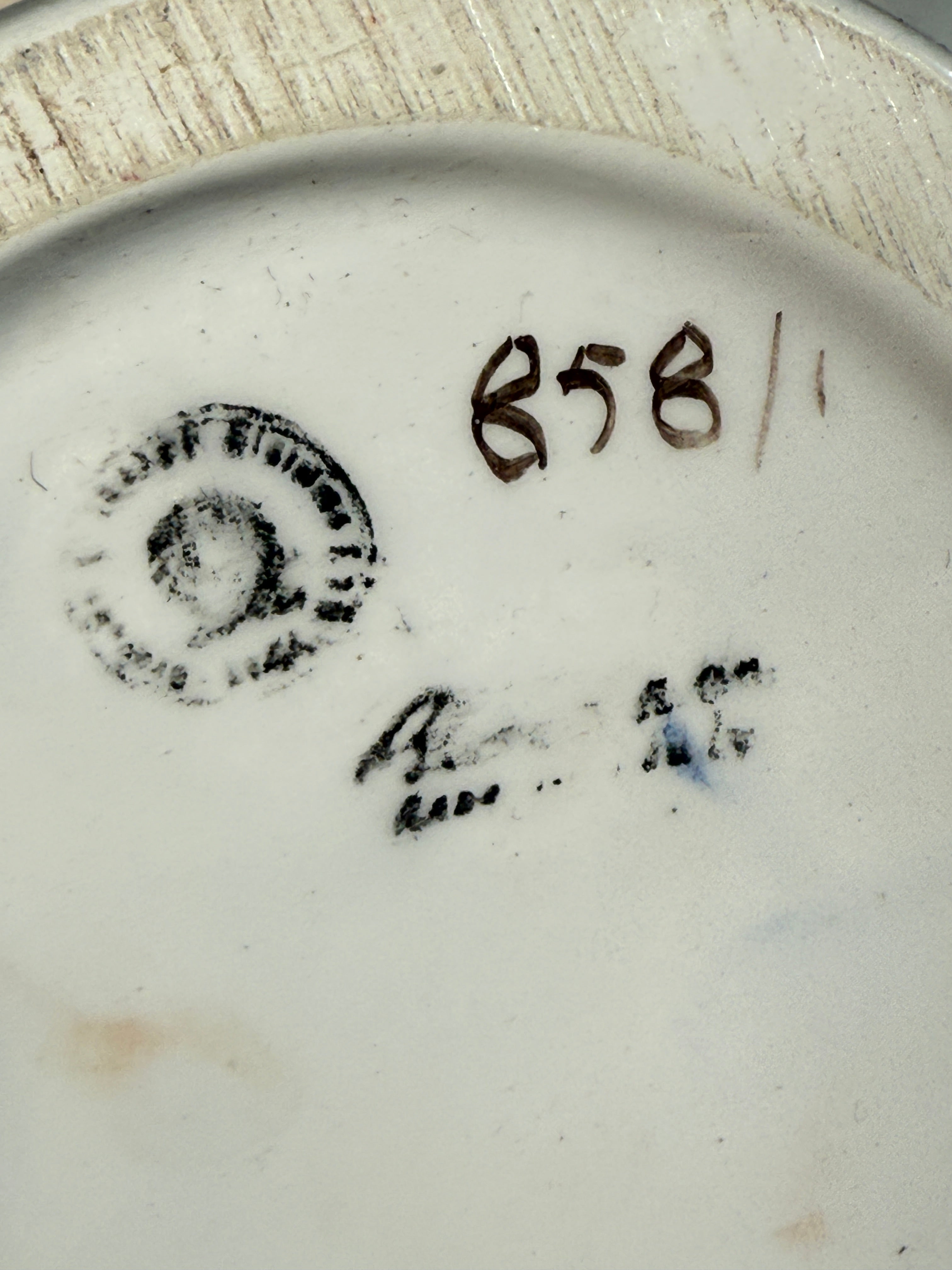 Stylized number '858' and decorative elements on a ceramic plate.