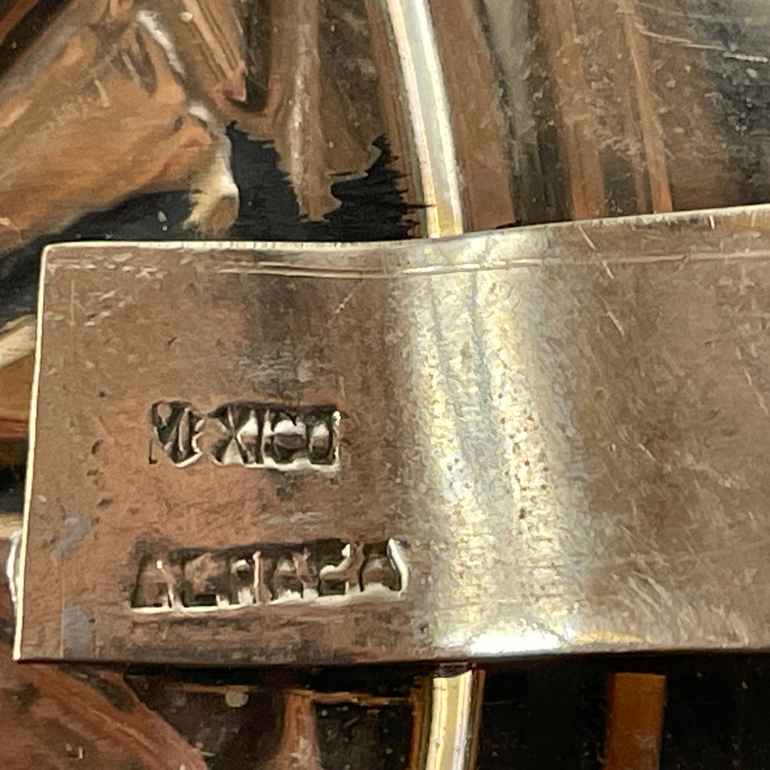 Close-up of a metallic object with 'Mexico' and 'Alpaca' stamps.