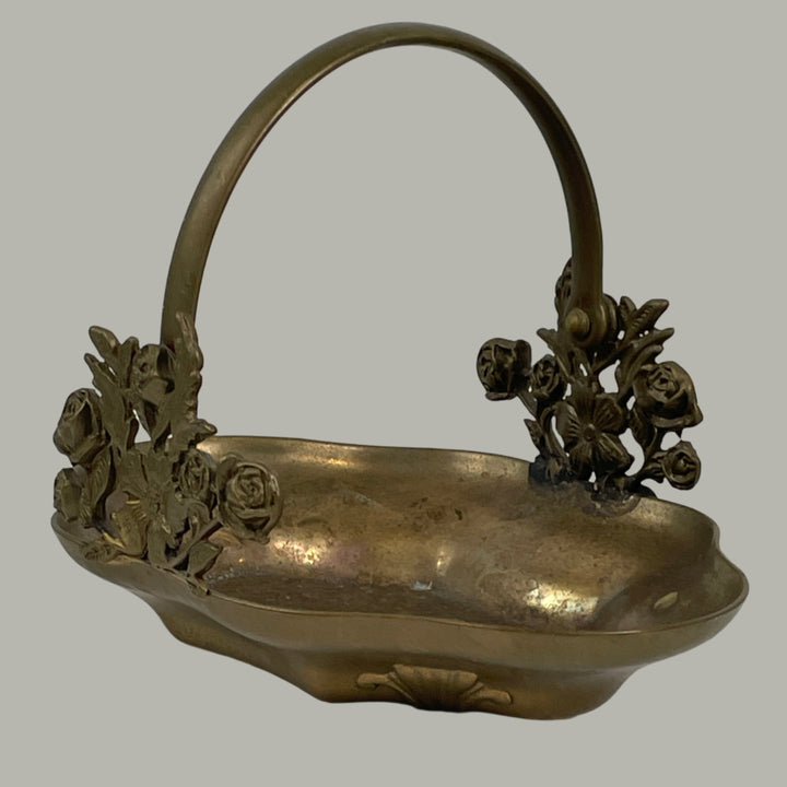 Bronze wall sconce with floral design on a white brick wall