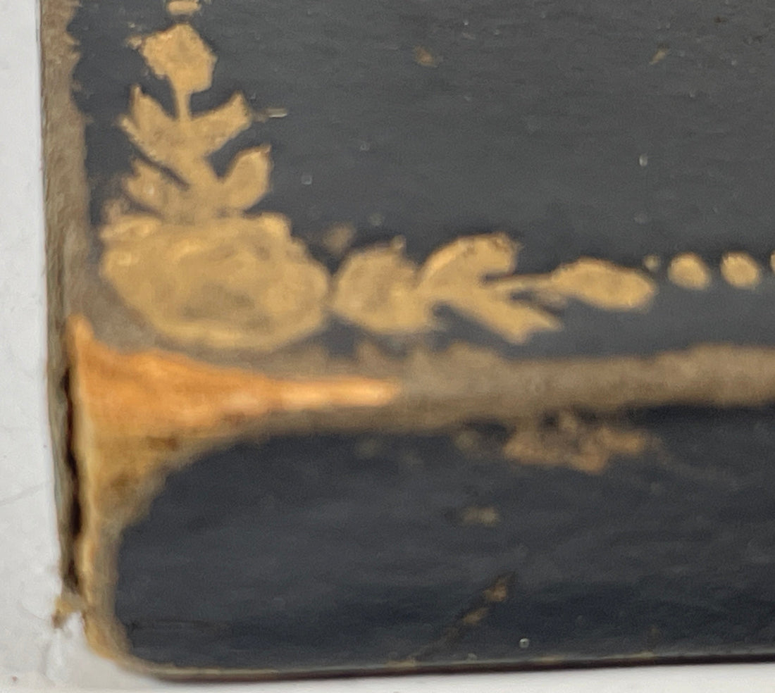 Corner of an old book with decorative gold leaf on a white background