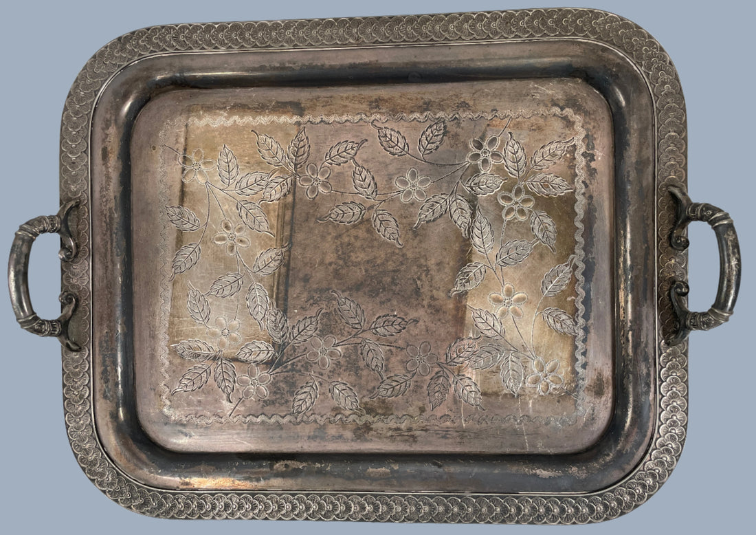 Silver tray with floral patterns on a white background